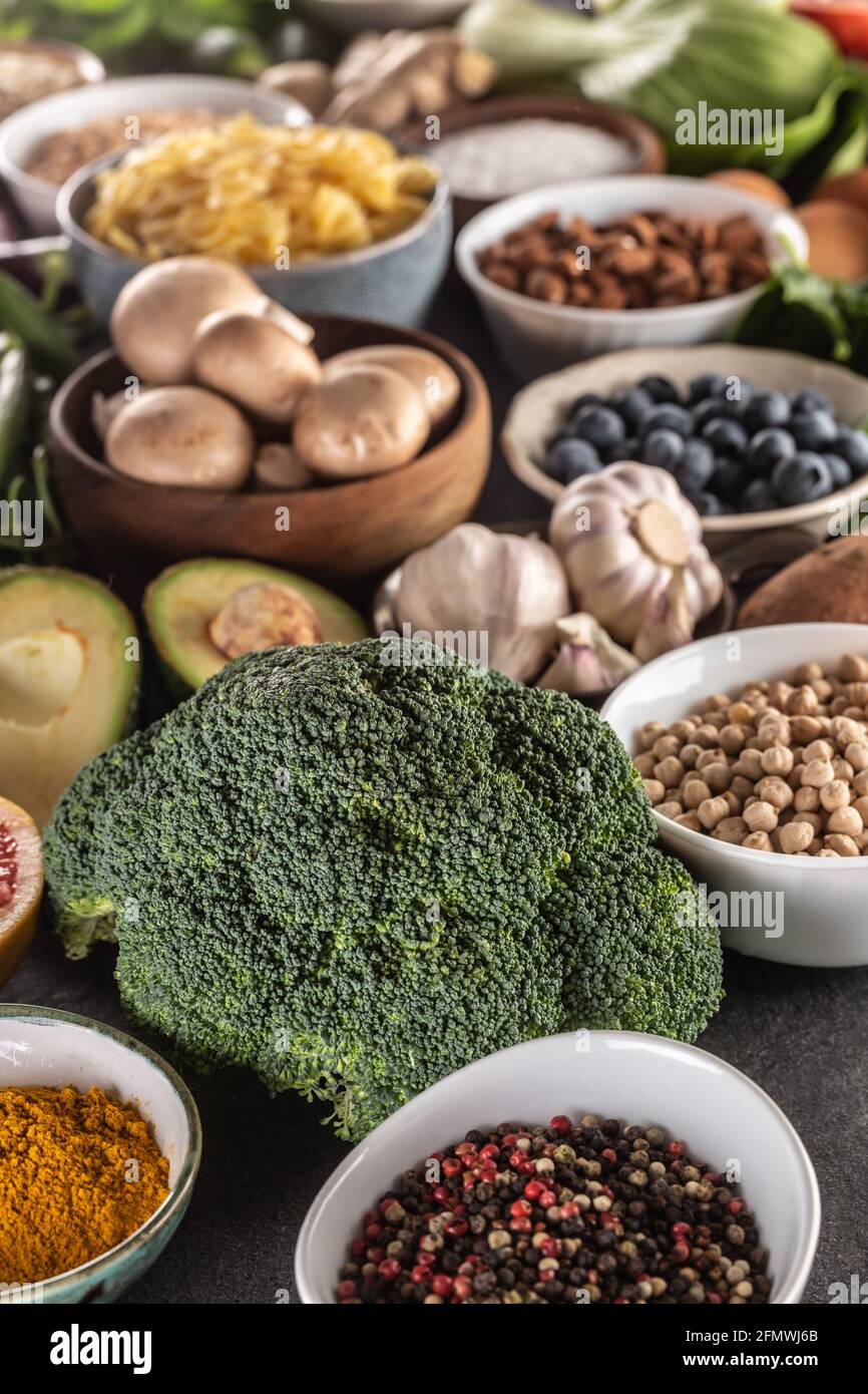 Auswahl an frischen Lebensmitteln und gesunde Ernährung auf Brokkoli konzentriert. Gemüse, Obst, Hülsenfrüchte und Getreide auf einem Betontisch. Stockfoto