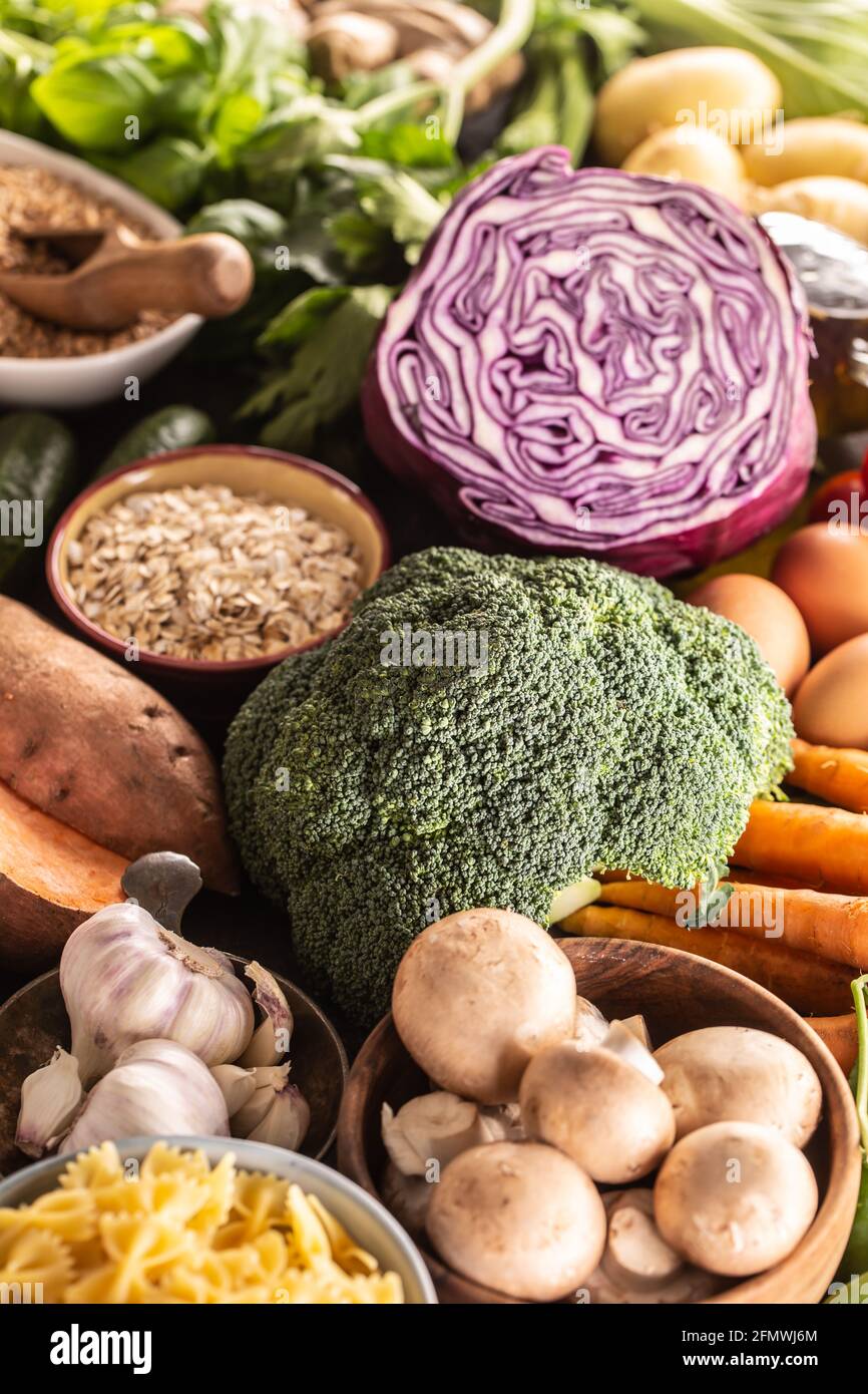 Auswahl an frischen Lebensmitteln und gesunde Ernährung auf Brokkoli konzentriert. Gemüse, Obst, Hülsenfrüchte und Getreide auf einem Betontisch. Stockfoto