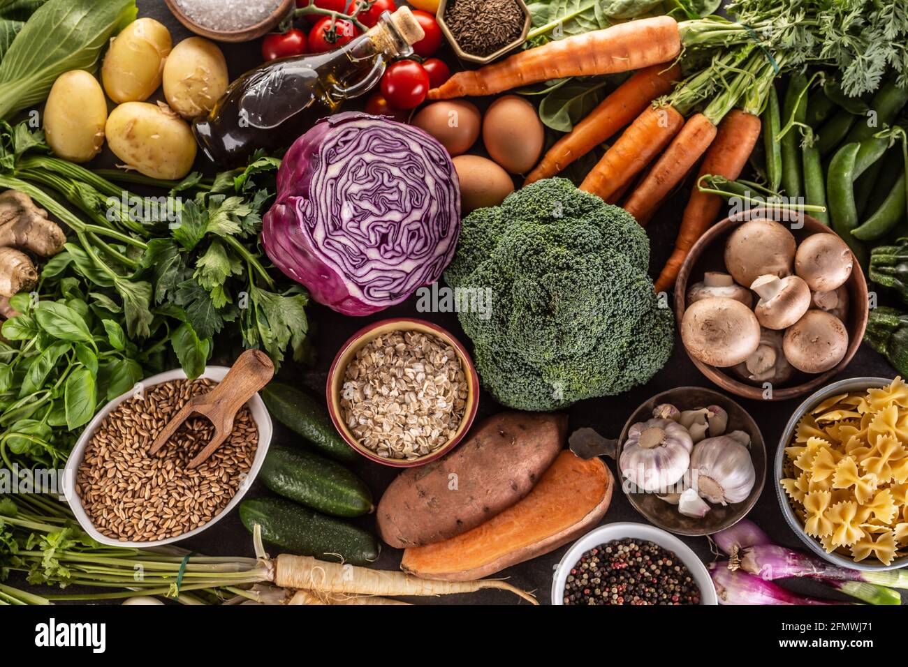 Auswahl an frischen Lebensmitteln und gesunder Ernährung: Gemüse, Obst, Hülsenfrüchte und Getreide auf einem Betontisch - Top of view. Stockfoto