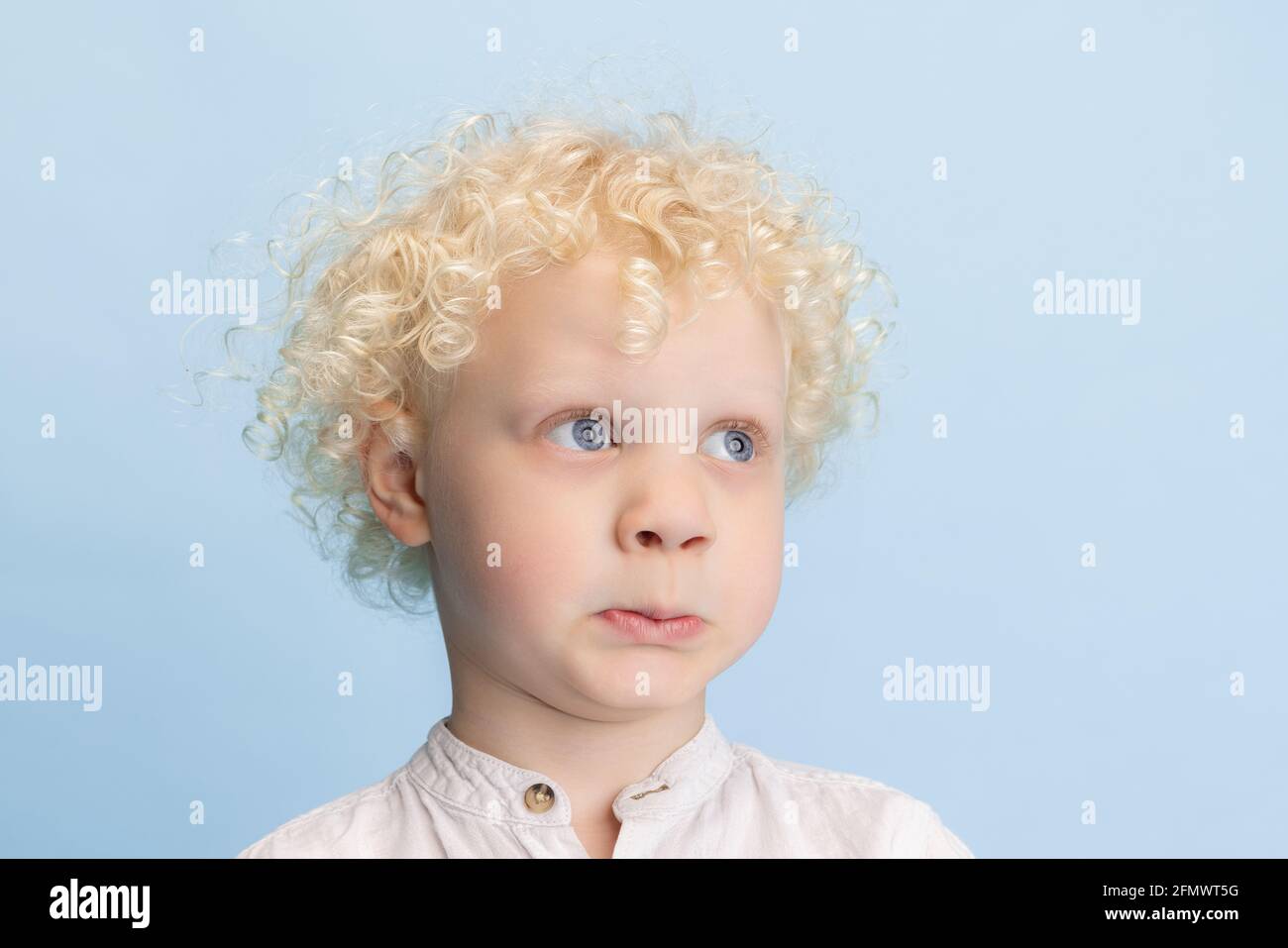 Nahaufnahme niedlichen kleinen Vorschuljungen posiert isoliert über blauen Studio Hintergrund. Stockfoto