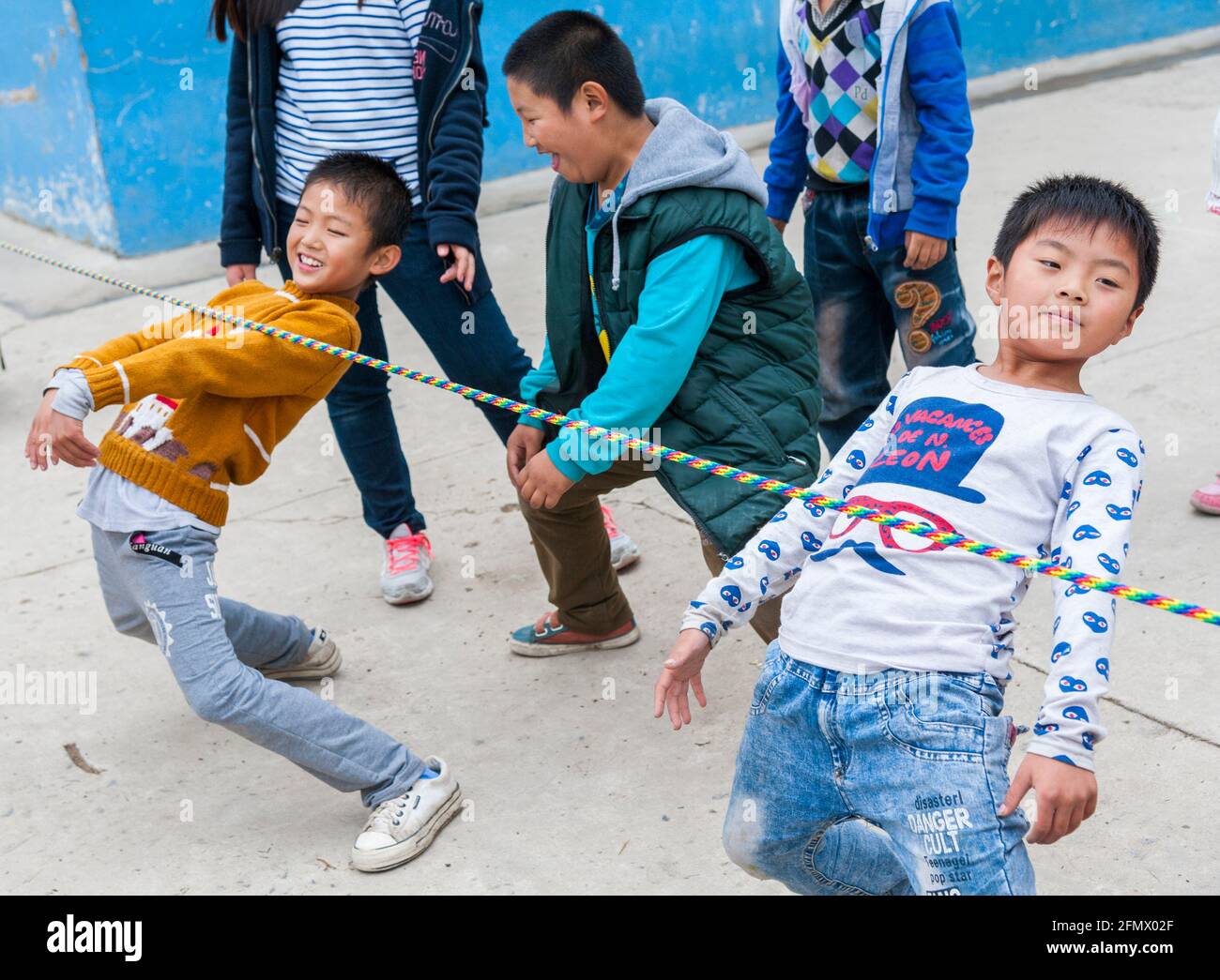 Grundschüler tanzen Limbo in einer ländlichen Schule in China. Stockfoto