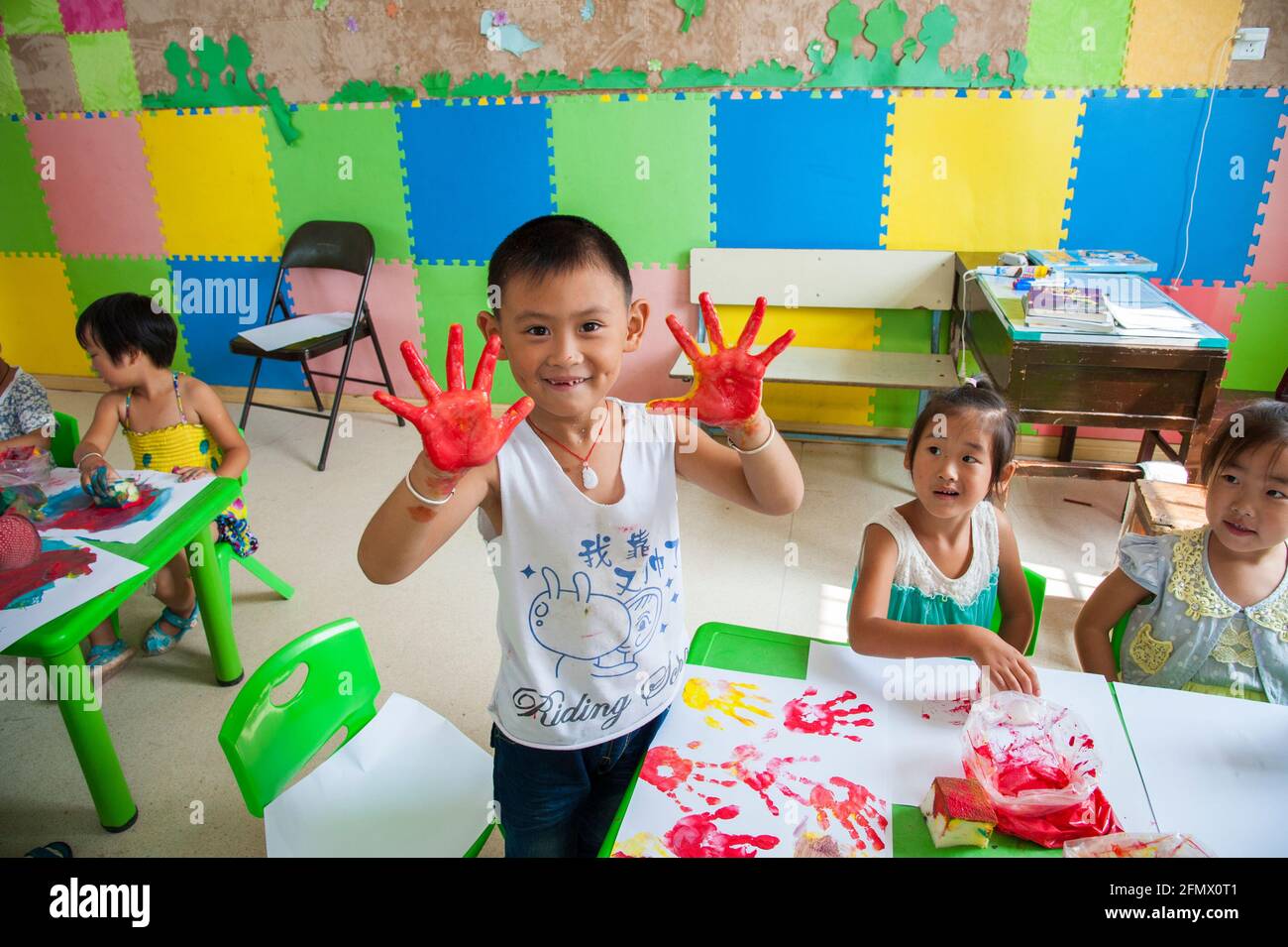 Kindergartenschüler einer ländlichen Schule im Bezirk Xiuning, Anhui, China, genießen den Fingermalkurs. Stockfoto