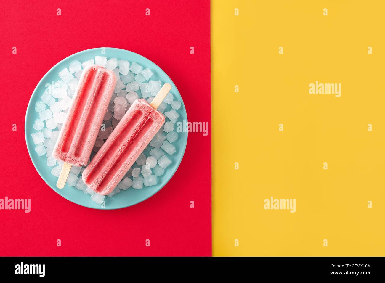 Erdbeerpopsicles mit Eis auf gelbem und rotem Hintergrund Stockfoto