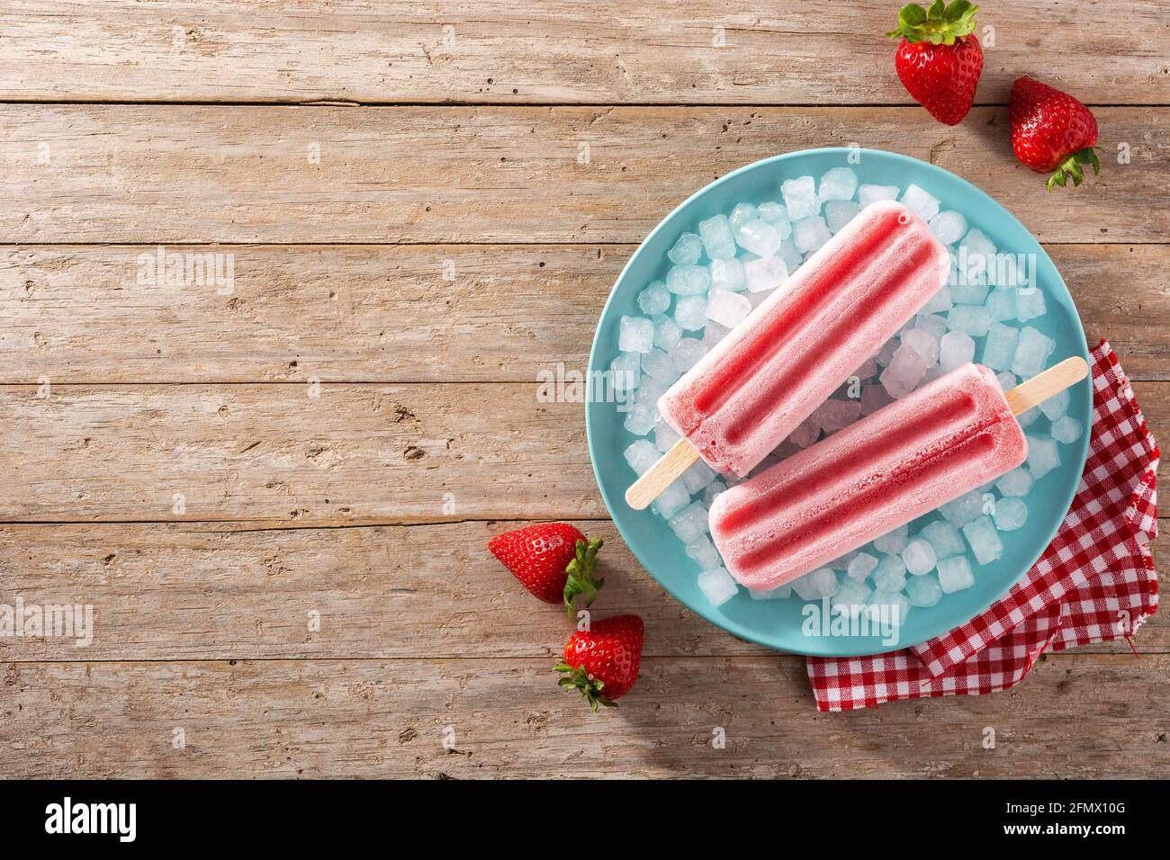 Erdbeerpopsicles mit Eis auf Holztisch Stockfoto