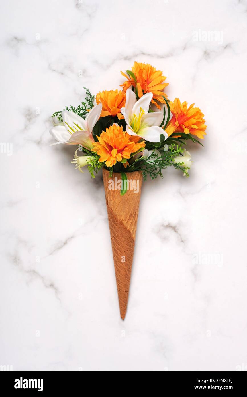 Eiskegel mit Blumen auf einem Marmortisch Stockfoto