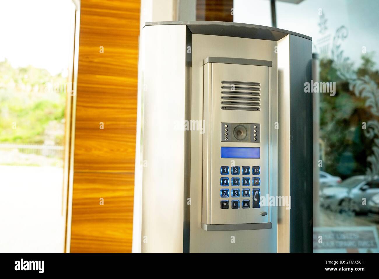 Nahaufnahme des Sicherheitssystem-Code-Geräts mit nummerierten Tasten auf moderner Gegensprechanlage mit blauem lcd-Bildschirm in der Nähe der Eingangstür. Elektronisches kodiertes Schloss Stockfoto