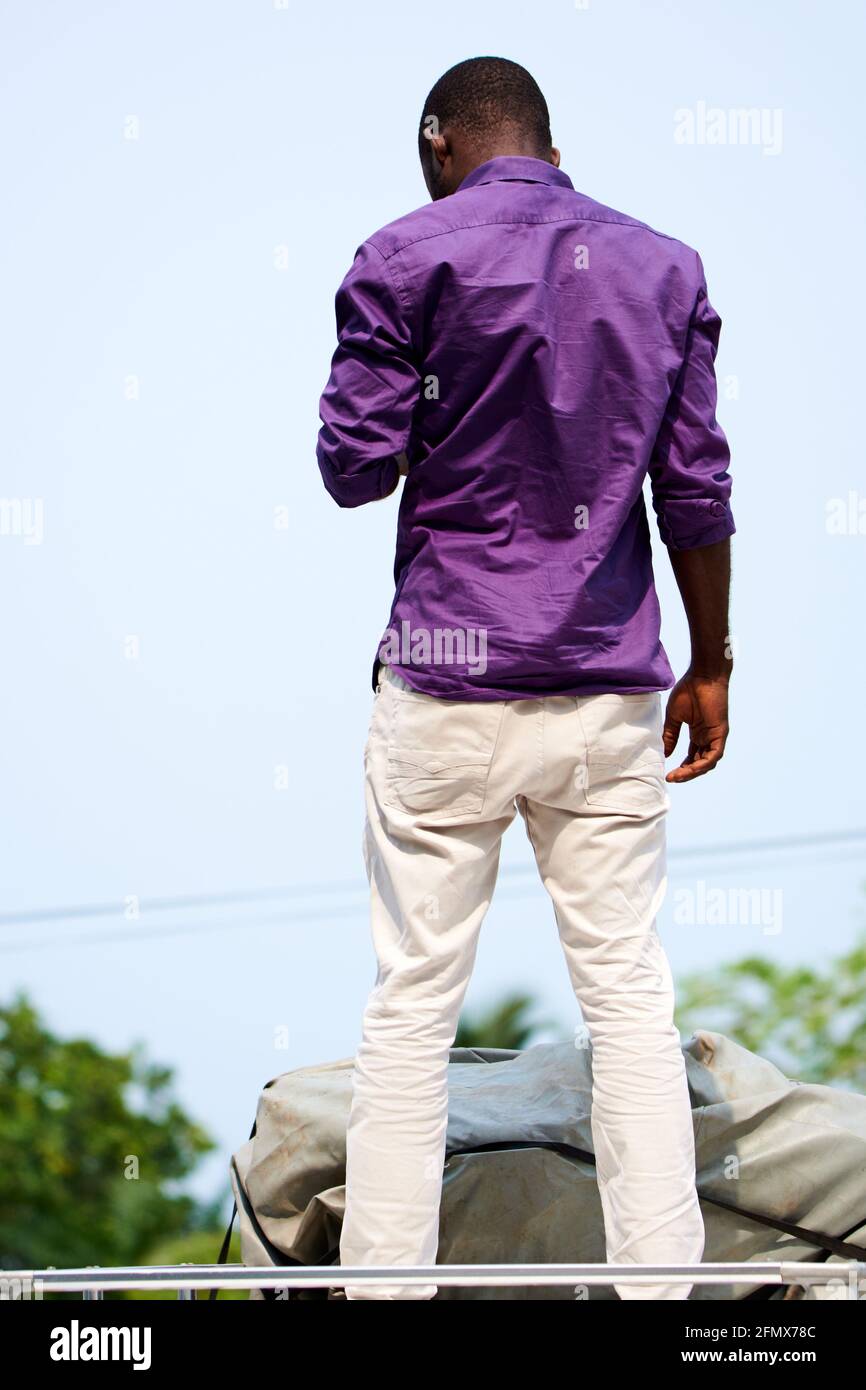 Rückseite eines jungen schwarzen Mannes mit einem violetten Hemd Stockfoto