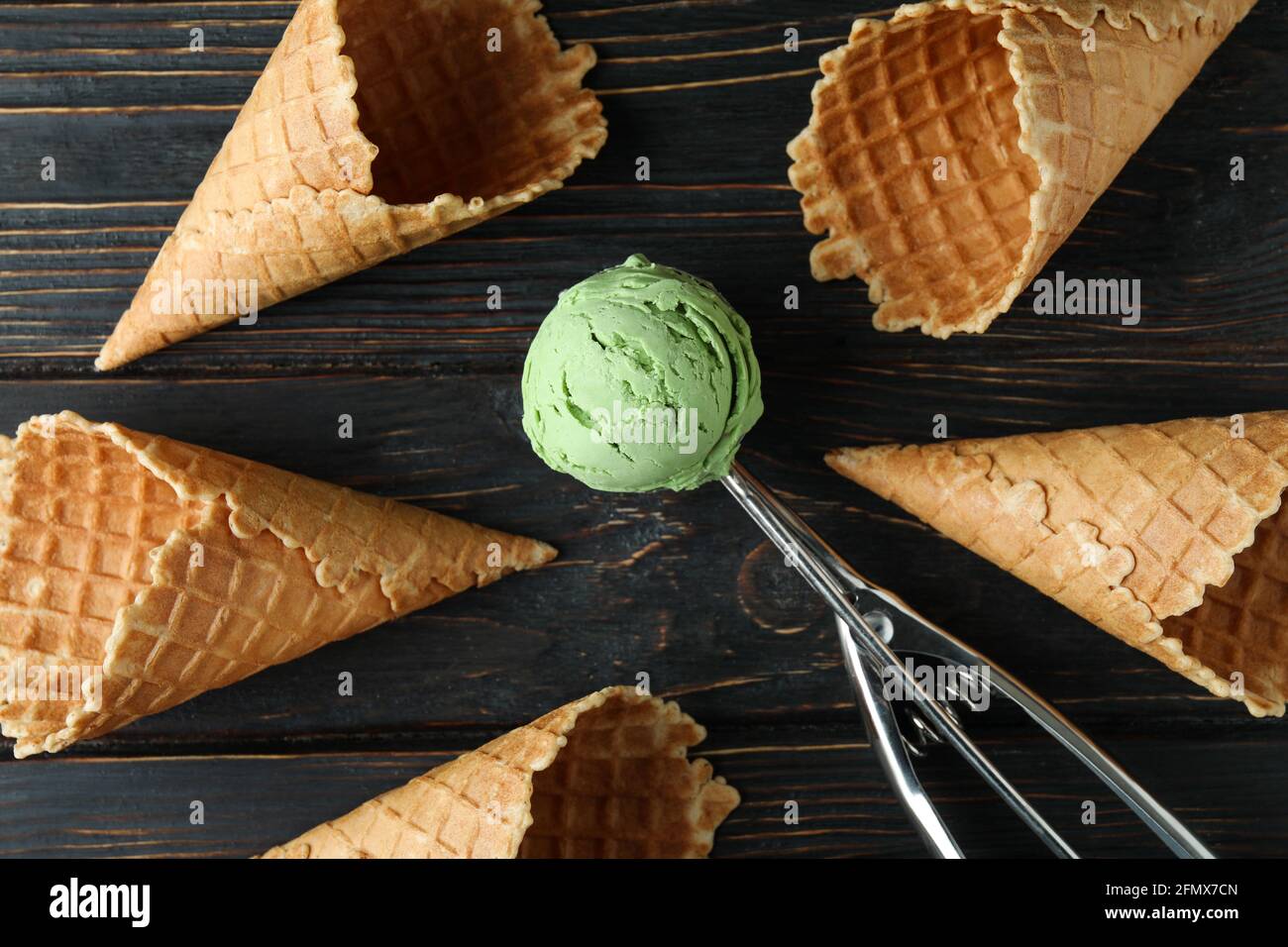 Schaufel mit Eis und Zapfen auf Holzhintergrund Stockfoto