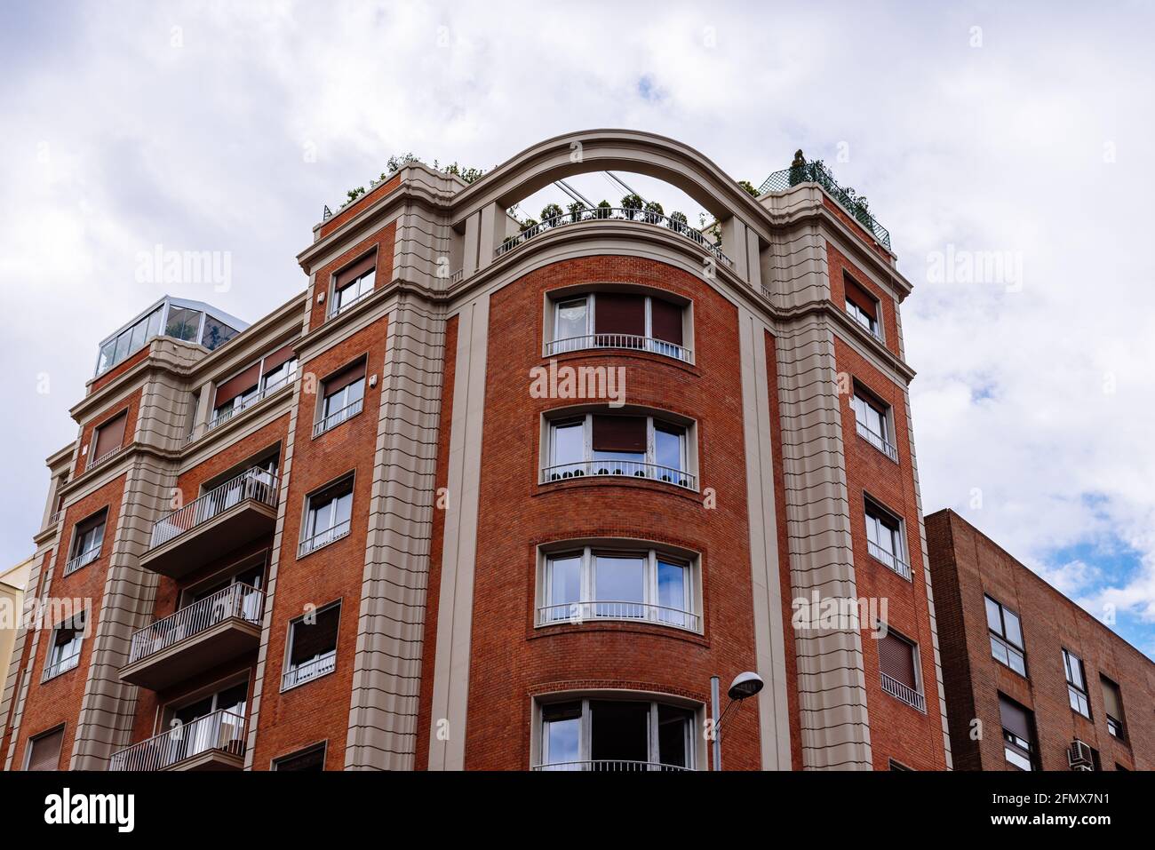 Luxuriöse Backsteinhäuser im Zentrum von Madrid. Niedrige Sicht der Fassade gegen den Himmel. Miete, Markt und Immobilieninvestitionen Stockfoto