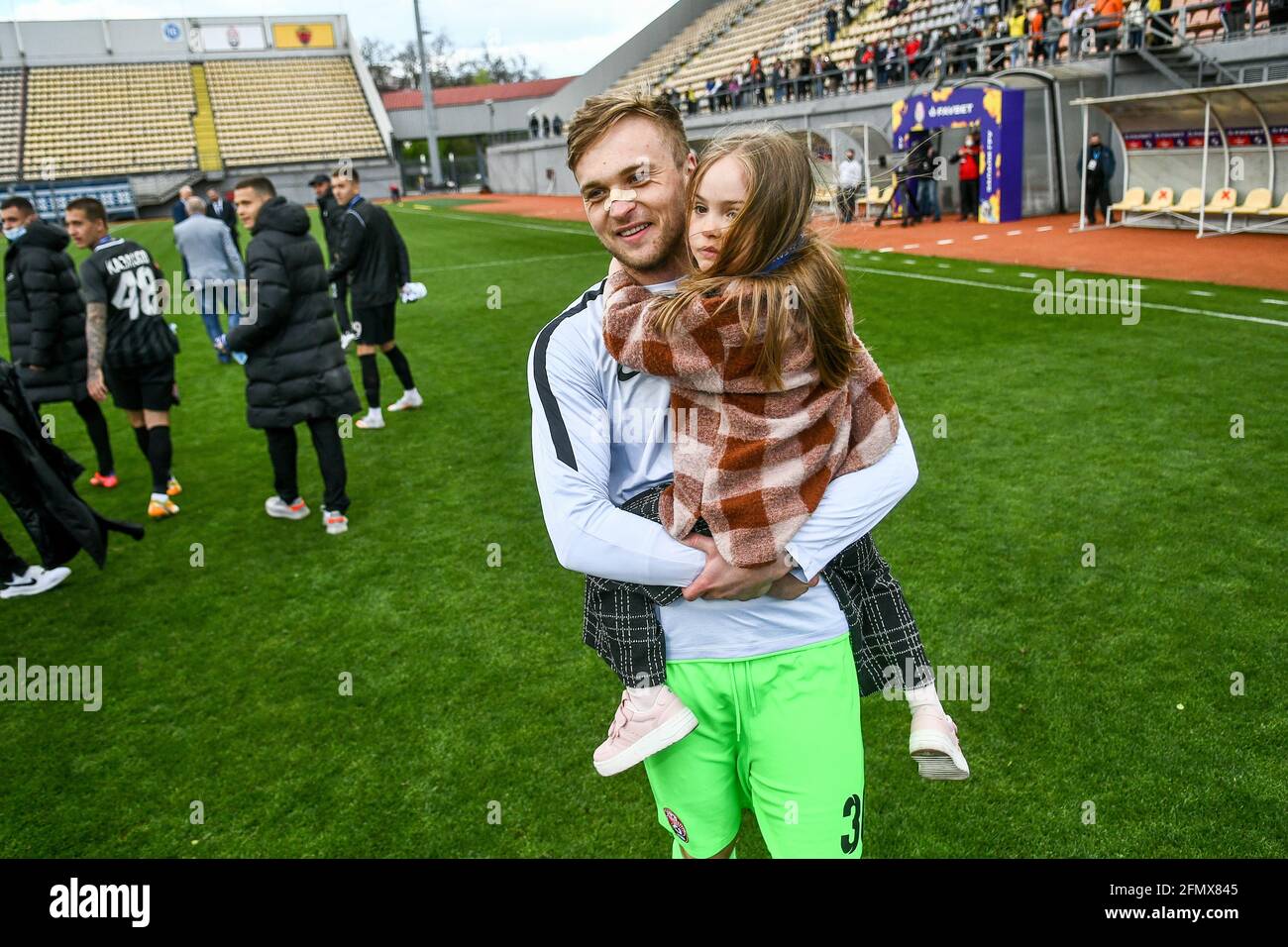 ZAPORISCHSCHSCHJA, UKRAINE - 9. MAI 2021 - Torhüter Mykyta Schewtschenko vom FC Zorya Luhansk hält seine Tochter, nachdem sein Team Bronze von den 2020/2021 U gewonnen hat Stockfoto