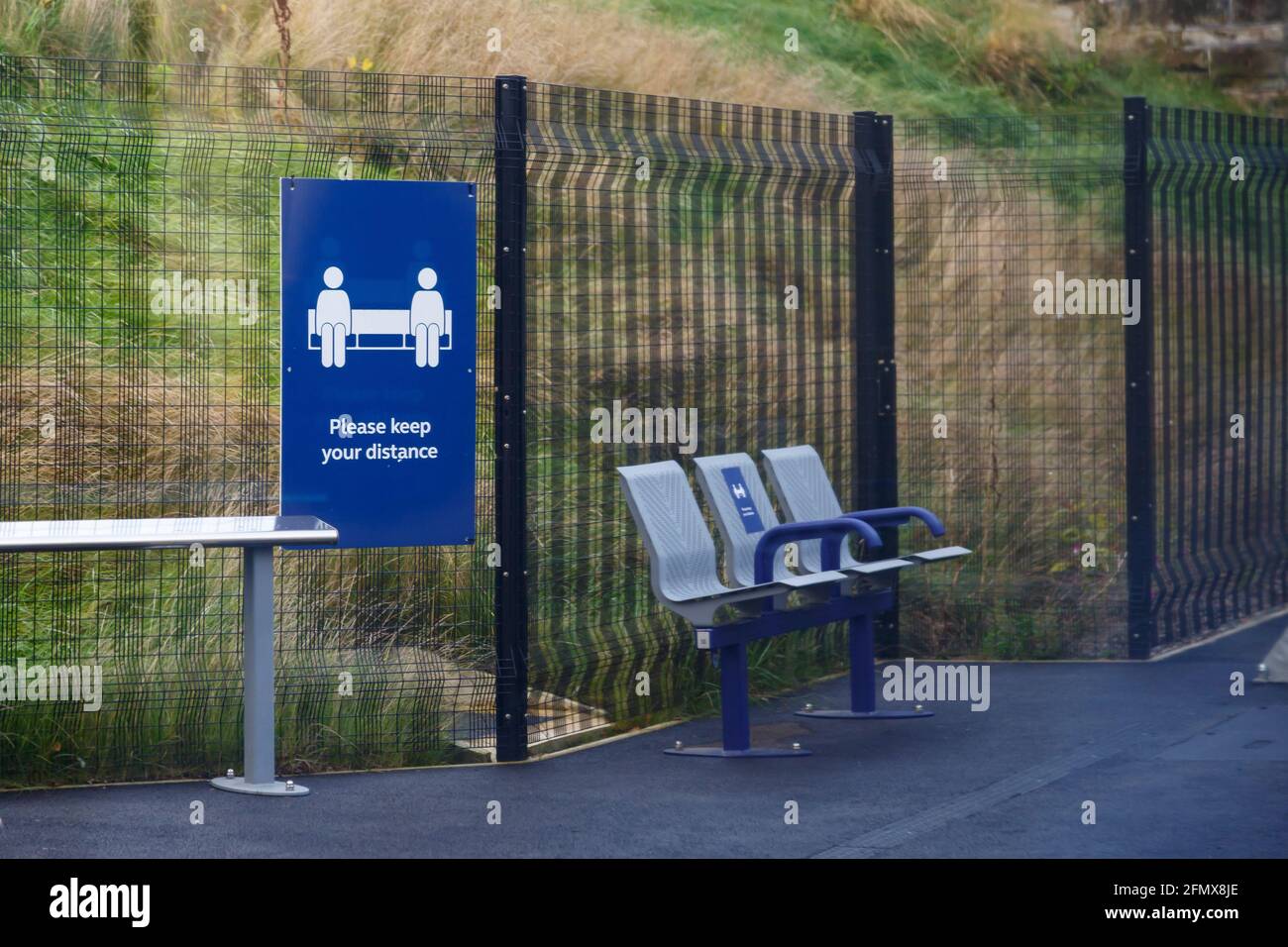 Bitte halten Sie Ihr Distance COVID-Schild am Bahnhof Stockfoto