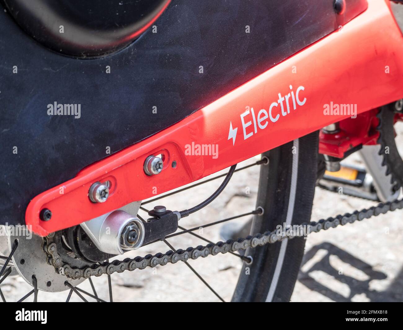 Nahaufnahme von Hinterrad, Nabe und Kette eines modernen elektrischen Citybikes Stockfoto