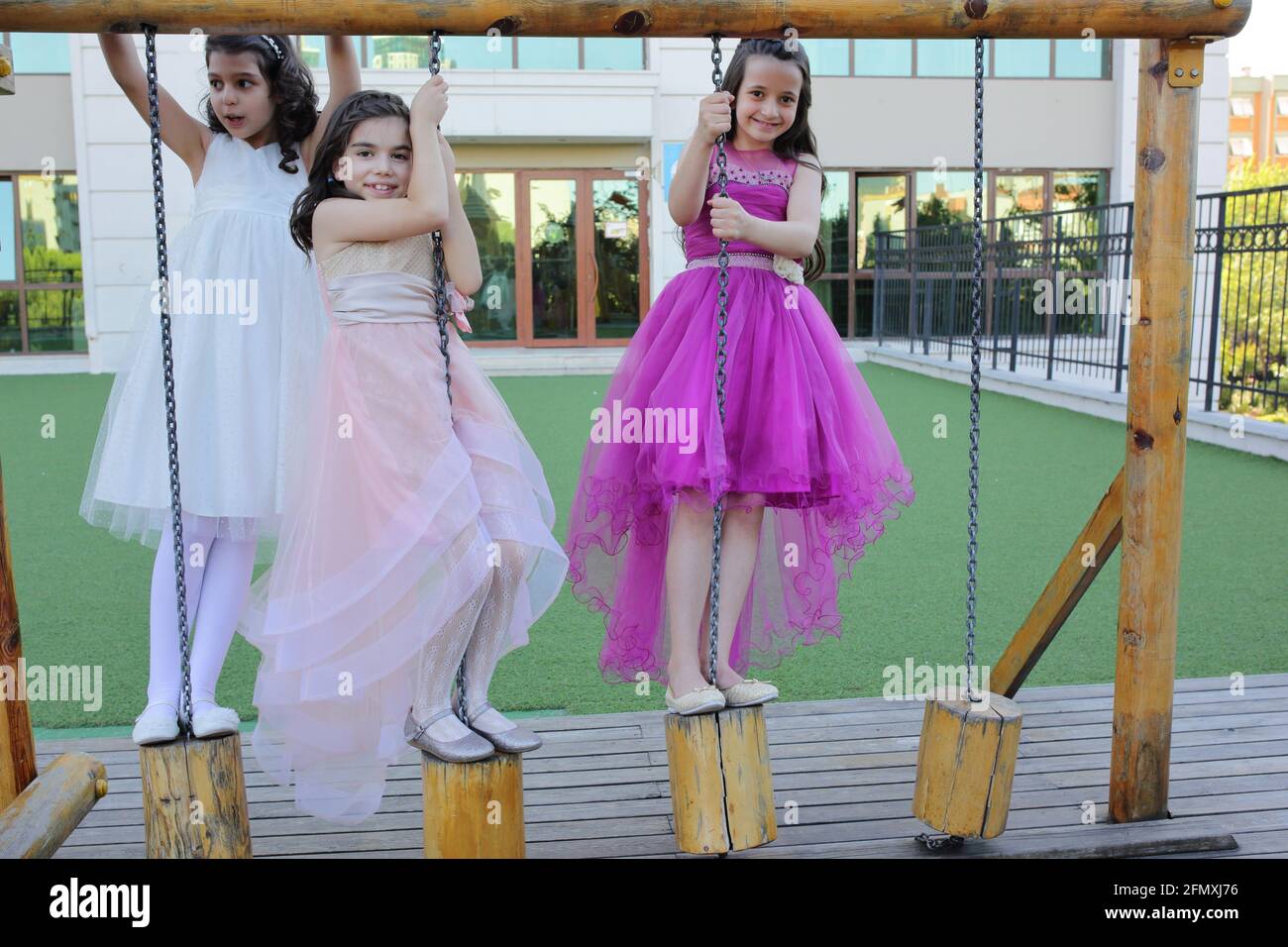 Kinder (drei Mädchen) mit Ballkleid auf dem Spielplatz Stockfotografie -  Alamy