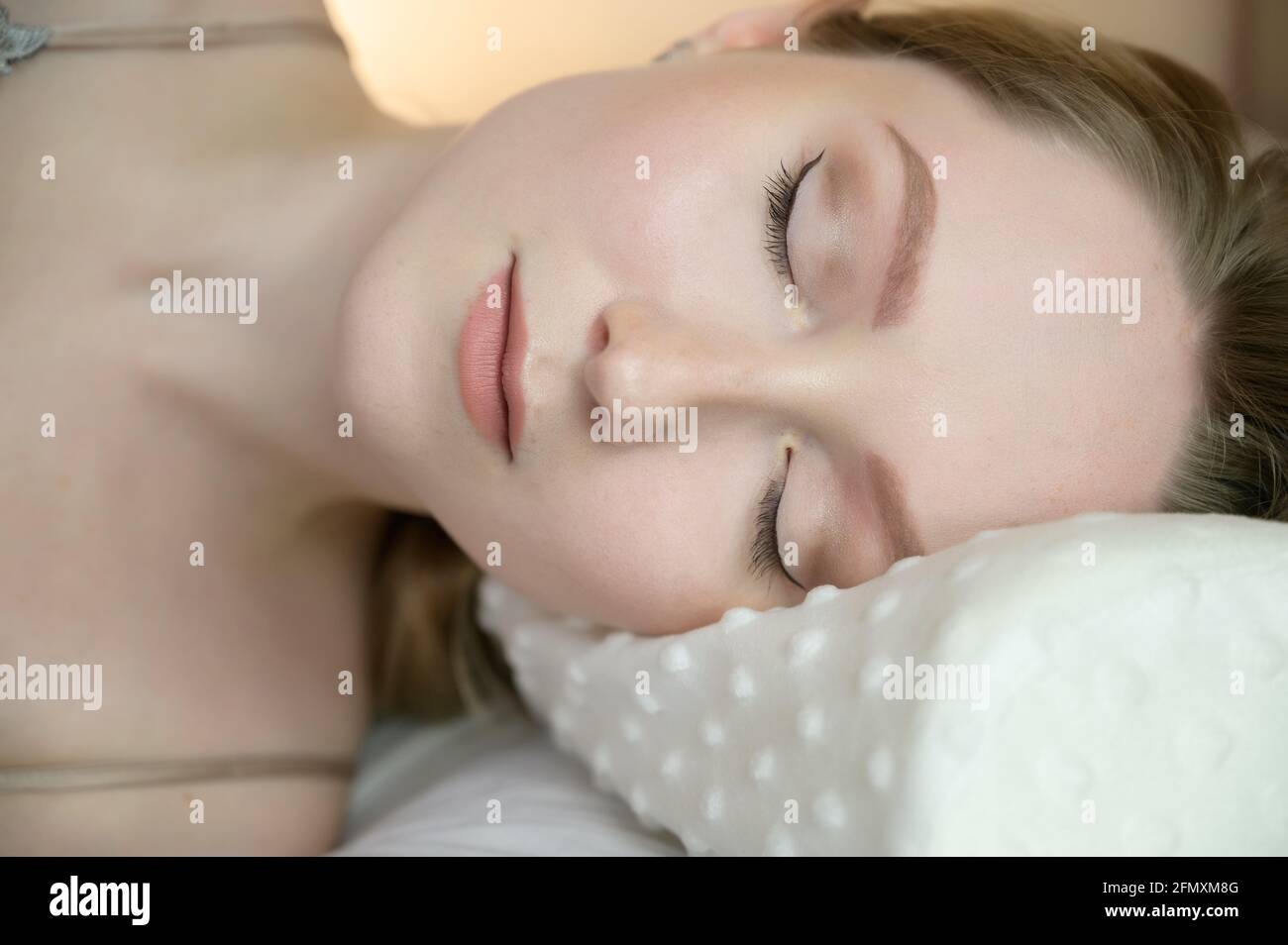 Porträt einer ruhigen jungen Frau auf dem Kissen. Stockfoto