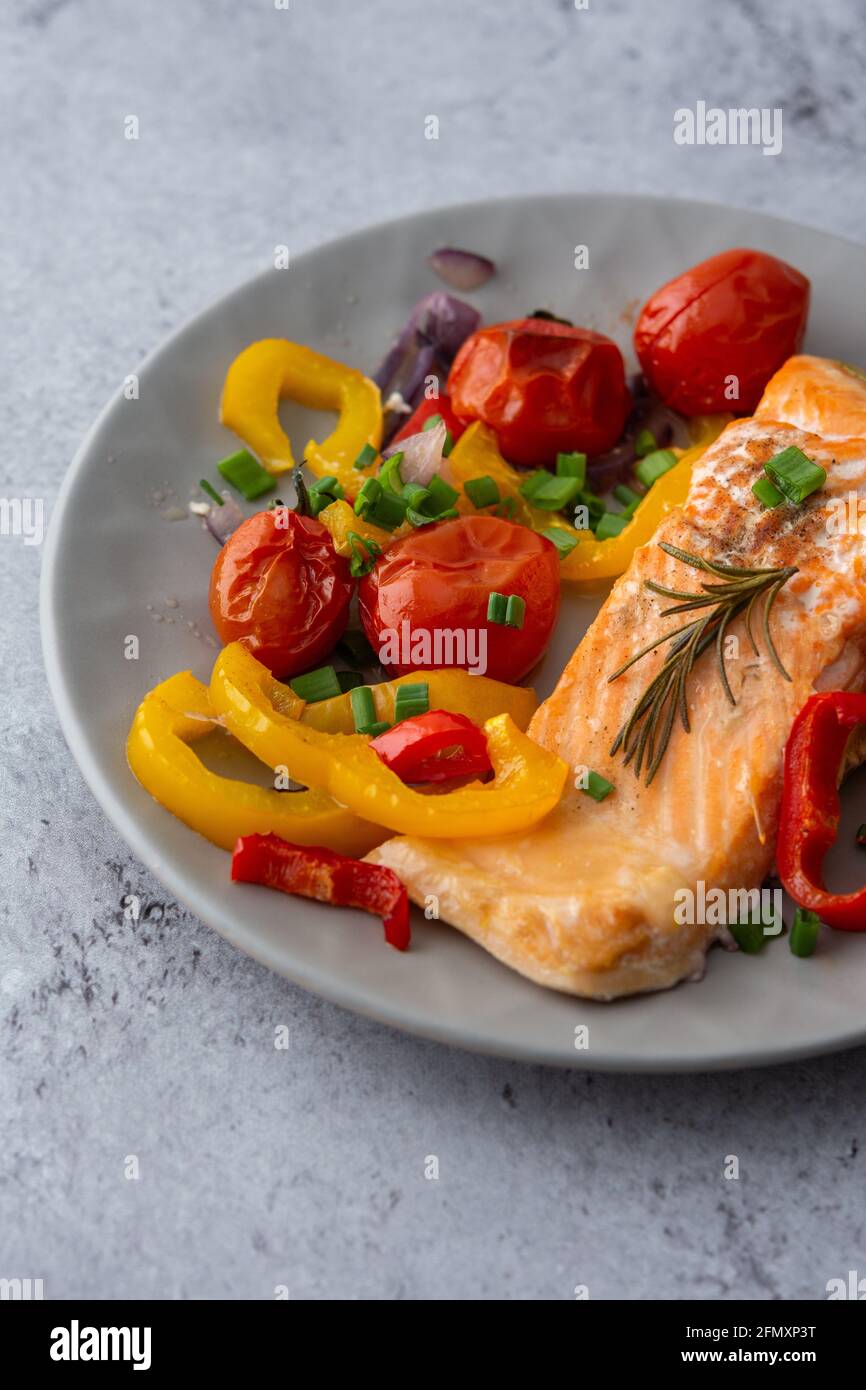 Gebackenes rotes Fischfilet Arktischer Saibling auf einem Teller mit Gemüse aus nächster Nähe, leckeres herzhaftes, gesundes Abendessen Stockfoto