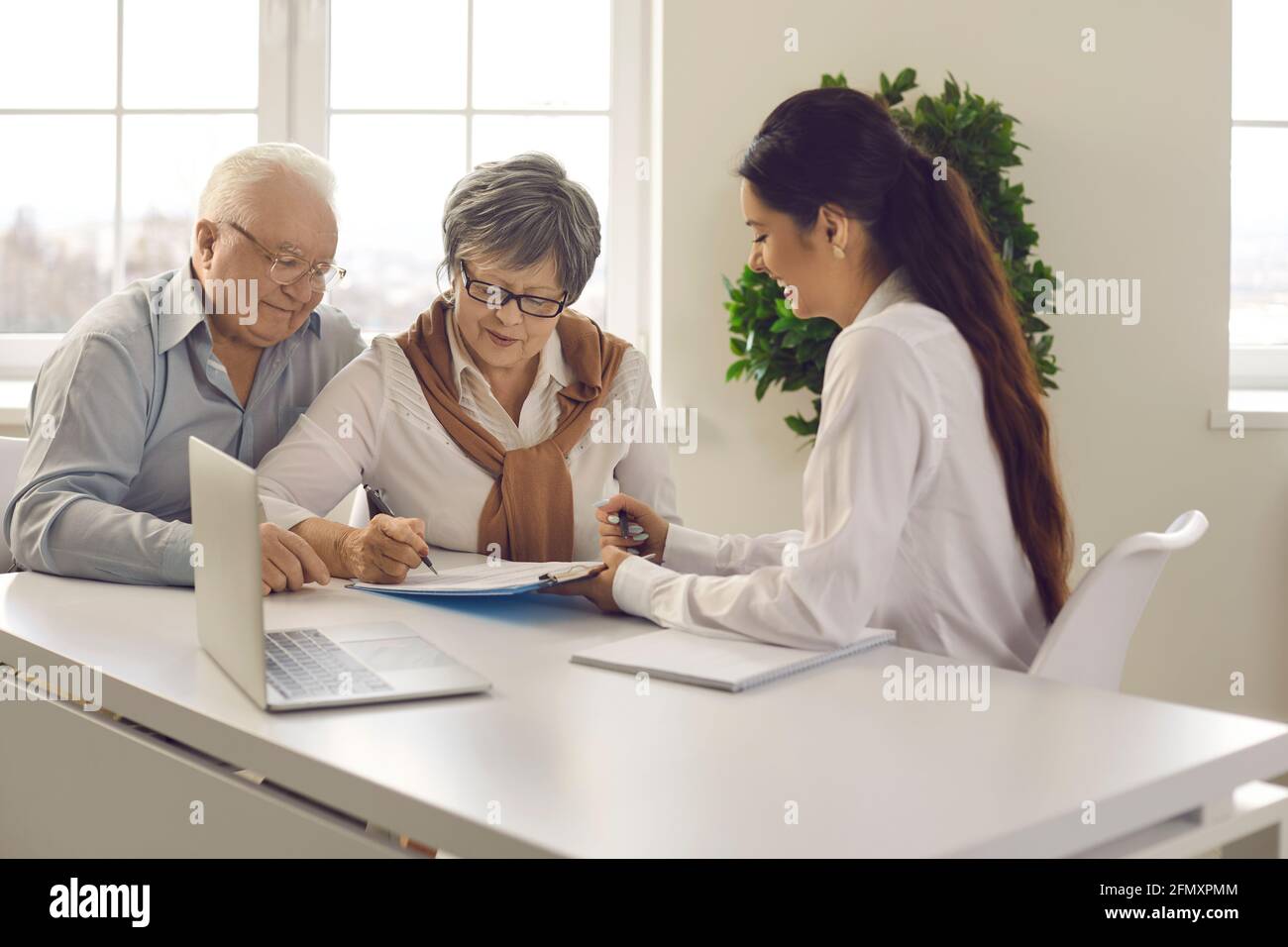 Altes verheiratetes Familienpaar, das beim Bankmanager einen Vertrag unterzeichnet Besprechung Stockfoto