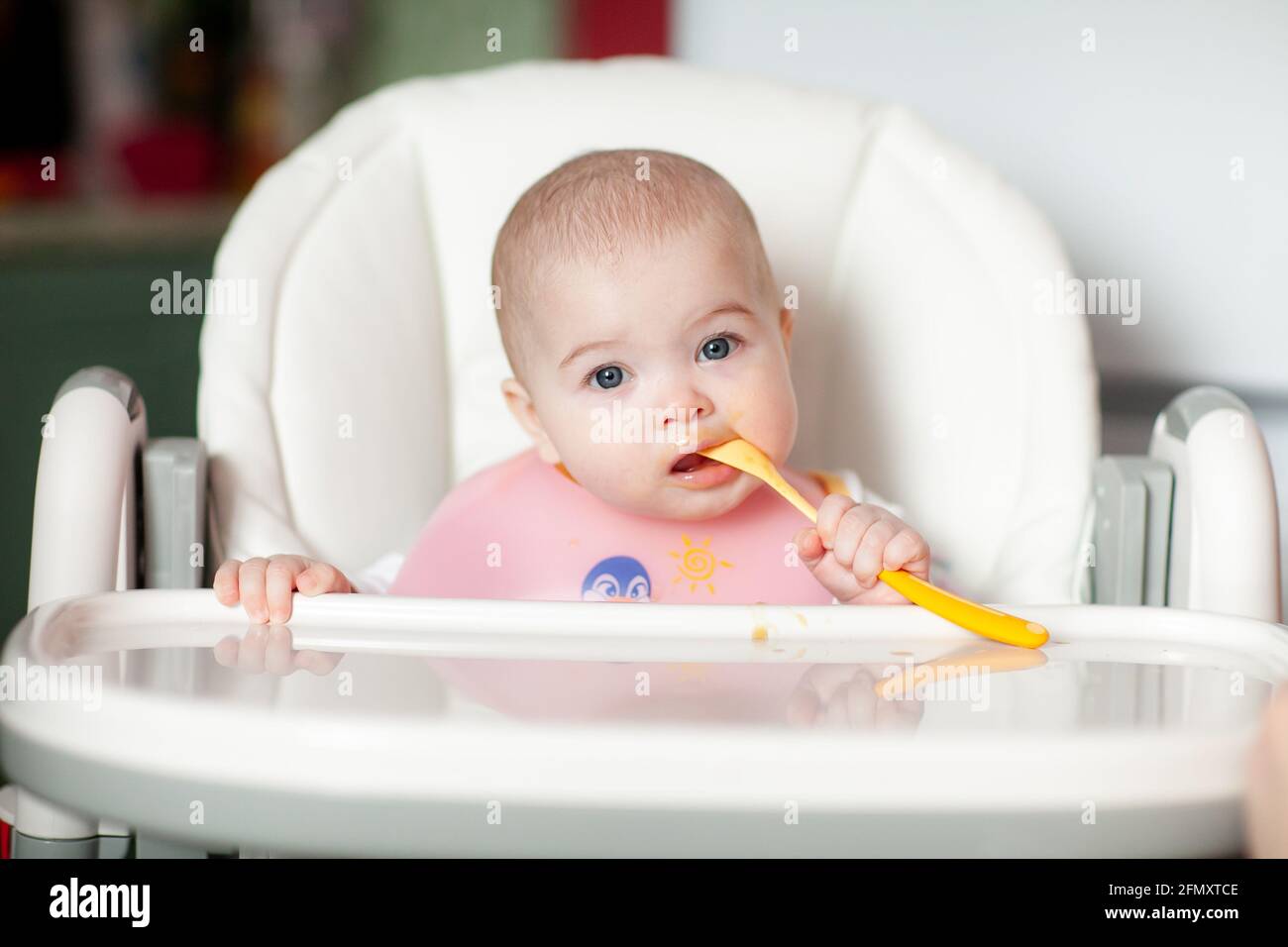 Glückliches Kleinkind Löffel isst sich. Schönes Baby essen püriert Stockfoto