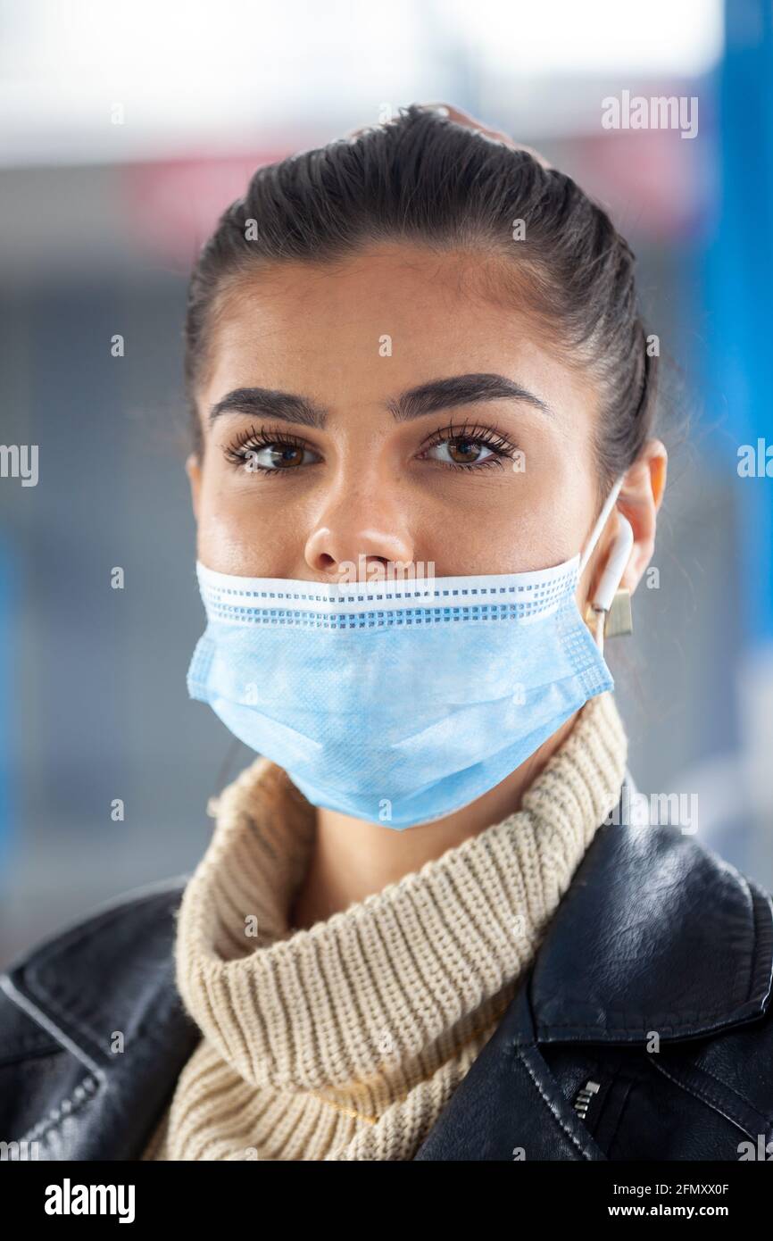 Eine Frau, die mit öffentlichen Verkehrsmitteln unterwegs ist und ihre Gesichtsmaske falsch trägt, bedeckt ihre Nase nicht. Stockfoto