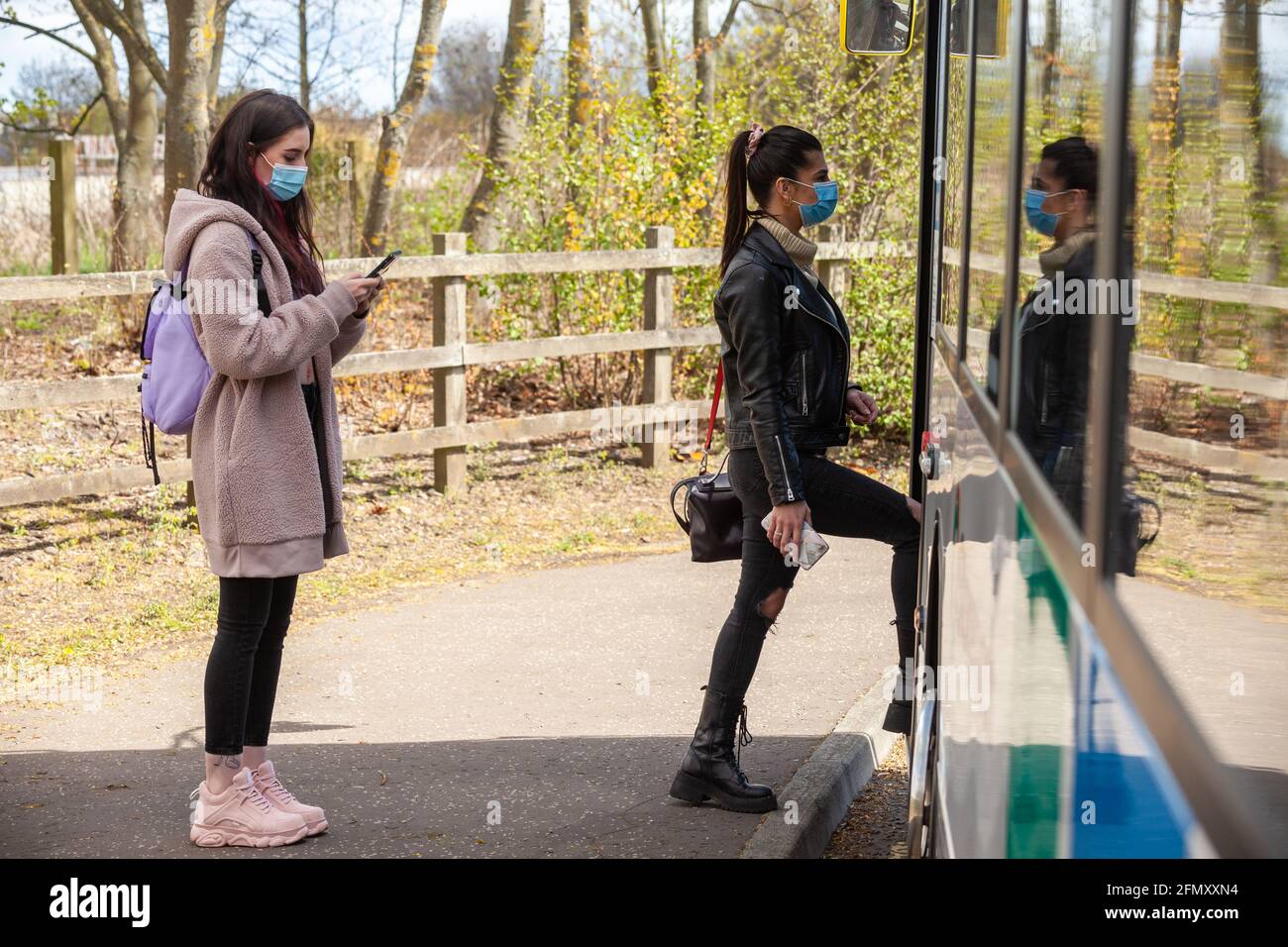 Zwei junge Frauen, die während der an Bord eines Busses gehen Tag Stockfoto