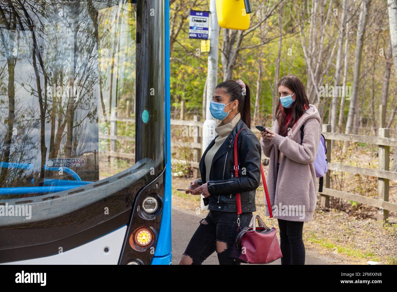 Zwei junge Frauen, die während der an Bord eines Busses gehen Tag Stockfoto