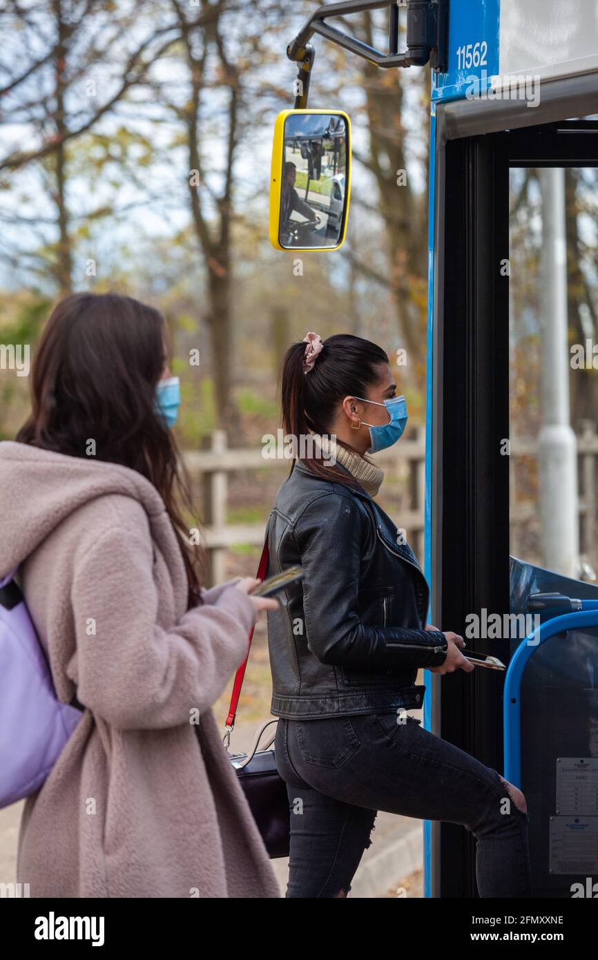 Zwei junge Frauen, die während der an Bord eines Busses gehen Tag Stockfoto