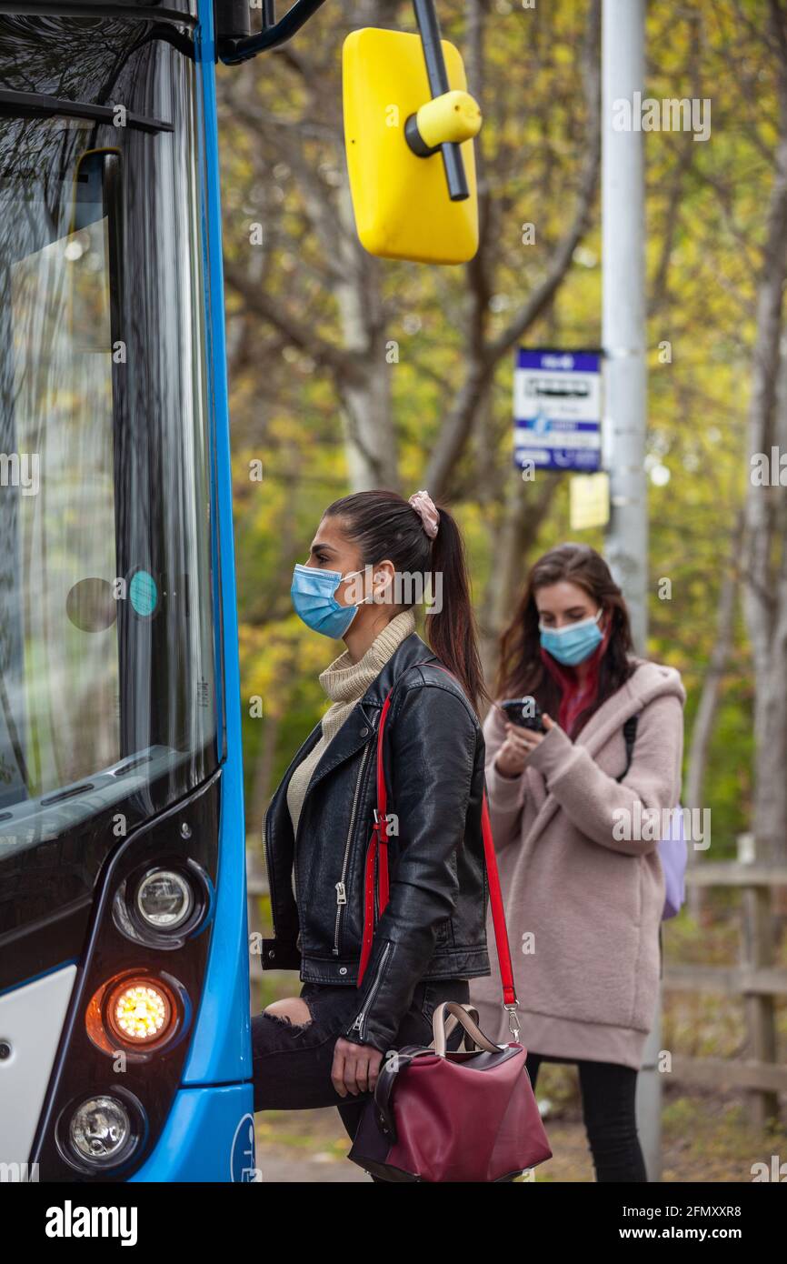 Zwei junge Frauen, die während der an Bord eines Busses gehen Tag Stockfoto