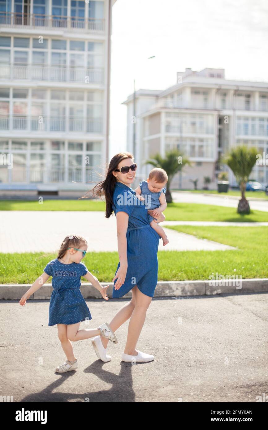 Junge Mutter mit Töchtern in Denim-Kleidern. Familienlook. Frohe Familie Stockfoto
