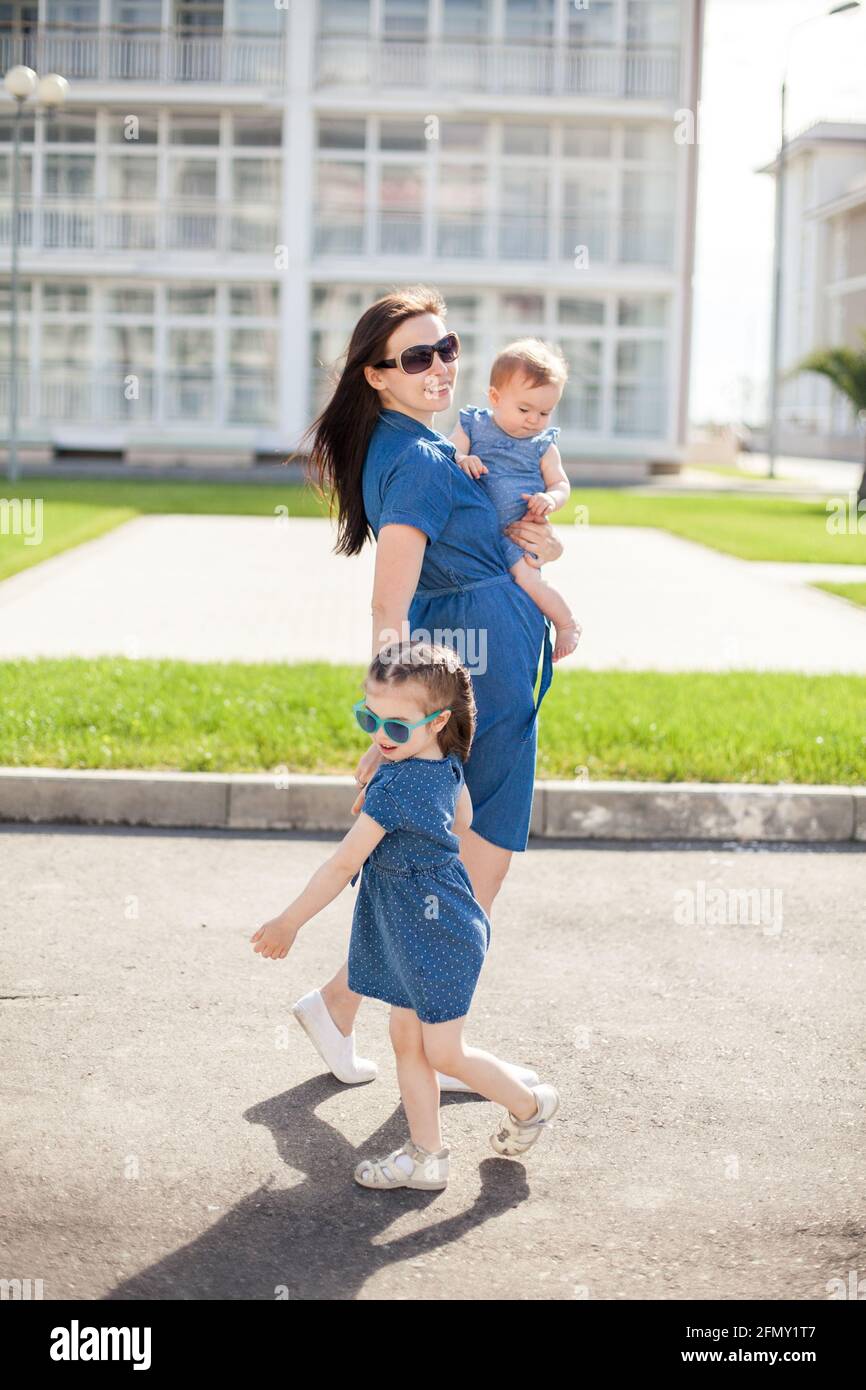 Junge Mutter mit Töchtern in Denim-Kleidern. Familienlook. Frohe Familie Stockfoto