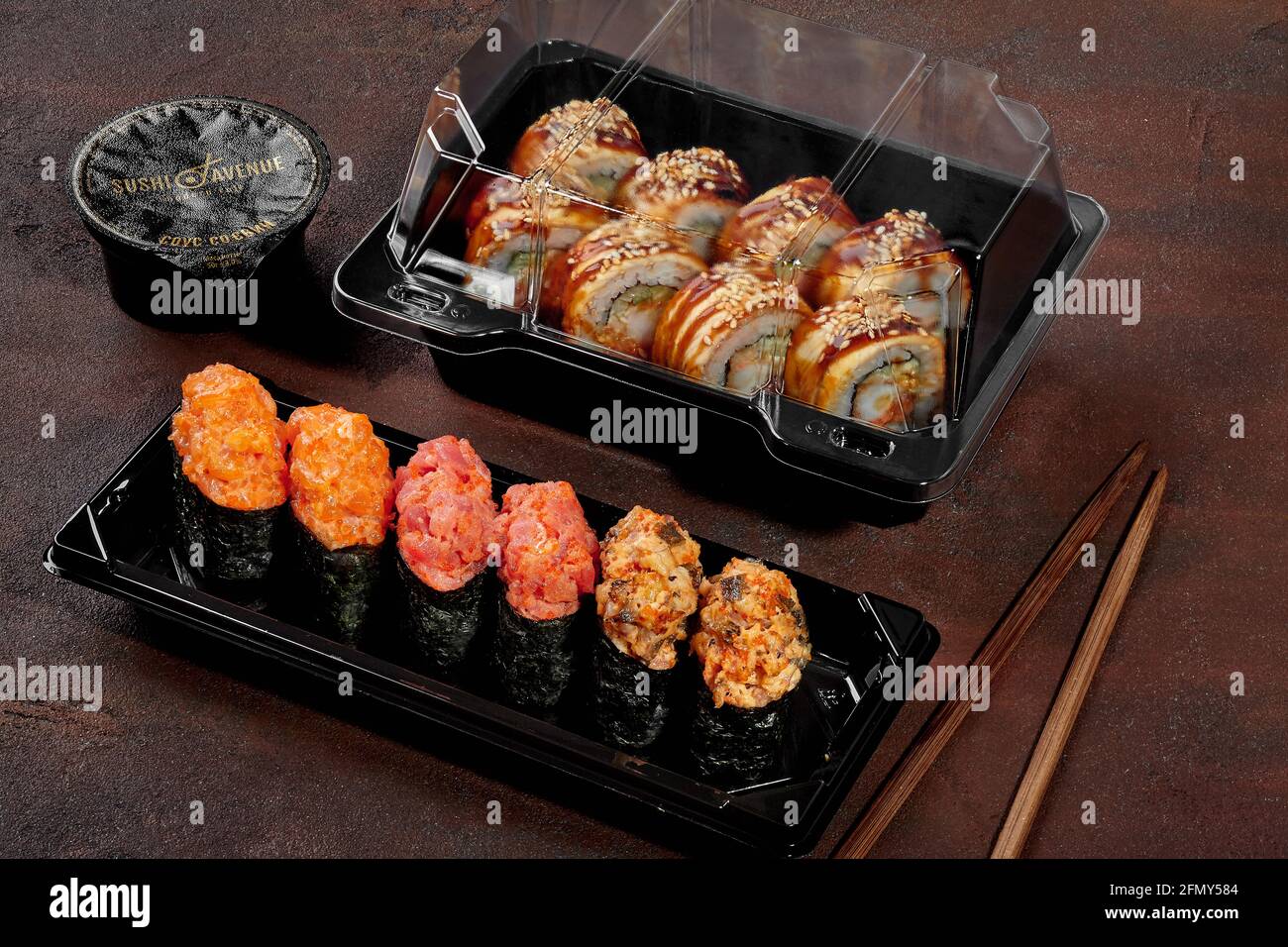 Sushi-Set aus Gunkan Maki und Rollen mit Aal Kunststoffkästen Stockfoto