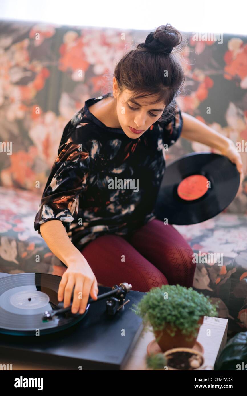 Frau spielt Musik auf Vinyl. Konzept zum Entspannen zu Hause. Stockfoto