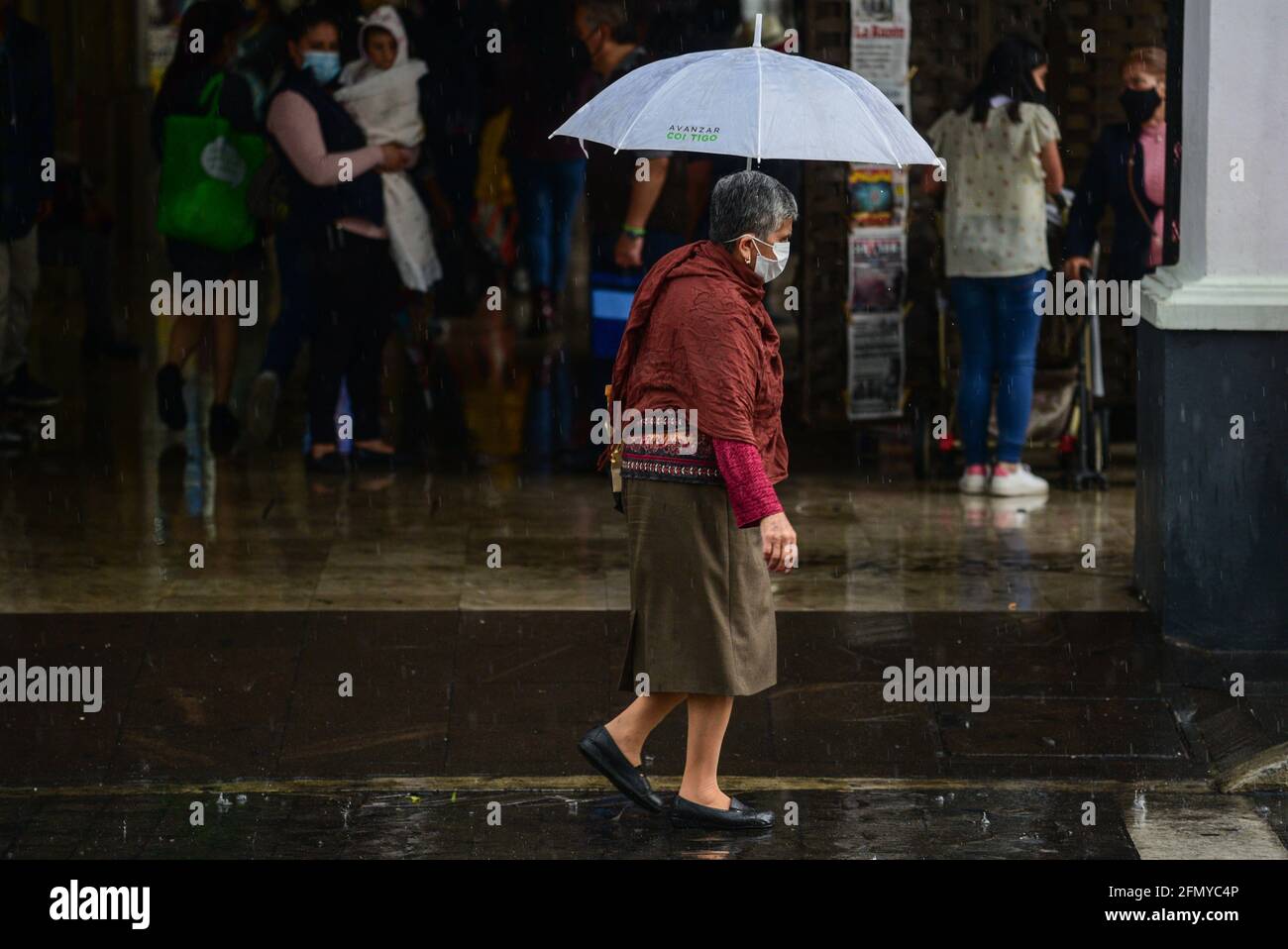 Non Exclusive: TOLUCA, MEXIKO - MAI 12: Ein älterer geht in der Innenstadt mit Sonnenschirmen, um vor den Regenfällen geschützt zu werden, da die Stadt angebrochen ist Stockfoto