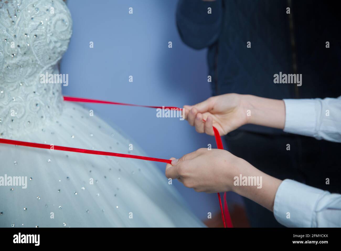 Verliere das Band am Bauch der Frau. Hochzeit . Brautjungfern schnürten die Brautleute. Schließen Sie das Band am Bauch der Frau. Schließen Sie das Band am Bauch Stockfoto