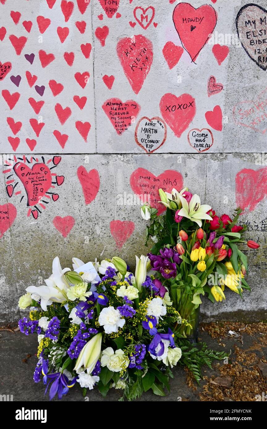 Blumensträuße, National COVID Memorial Wall, ein öffentliches Wandgemälde zum Gedenken an die Opfer der COVID-19 Pandemie.South Bank Walkway, Westminster, London. VEREINIGTES KÖNIGREICH Stockfoto