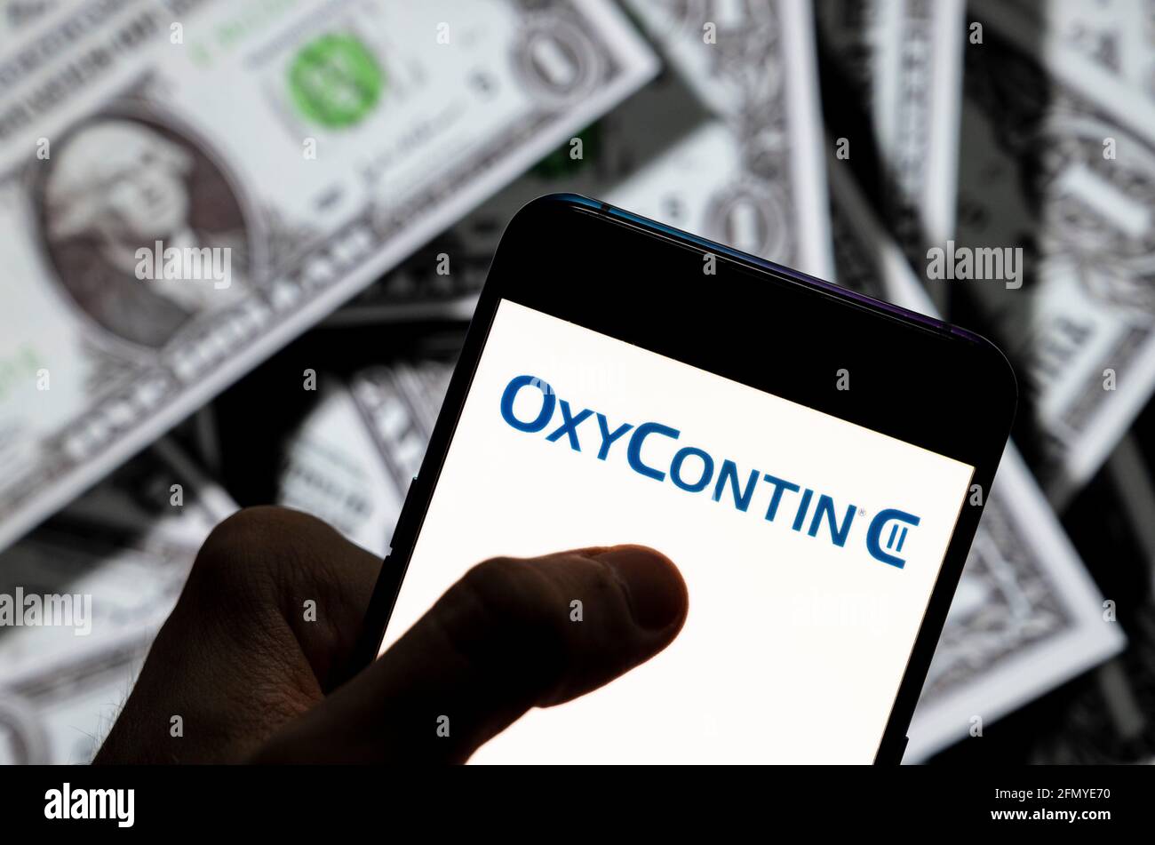 China. April 2021. In dieser Abbildung wurde das Schmerzmittel OxyContin vom Pharmaunternehmen der Familie Sackler hergestellt, das die Schuld für die Opioidkrise der USA, Purdue Pharma, trägt. Das Logo wurde auf einem Smartphone mit US-Dollar-Währung im Hintergrund angezeigt. Kredit: SOPA Images Limited/Alamy Live Nachrichten Stockfoto