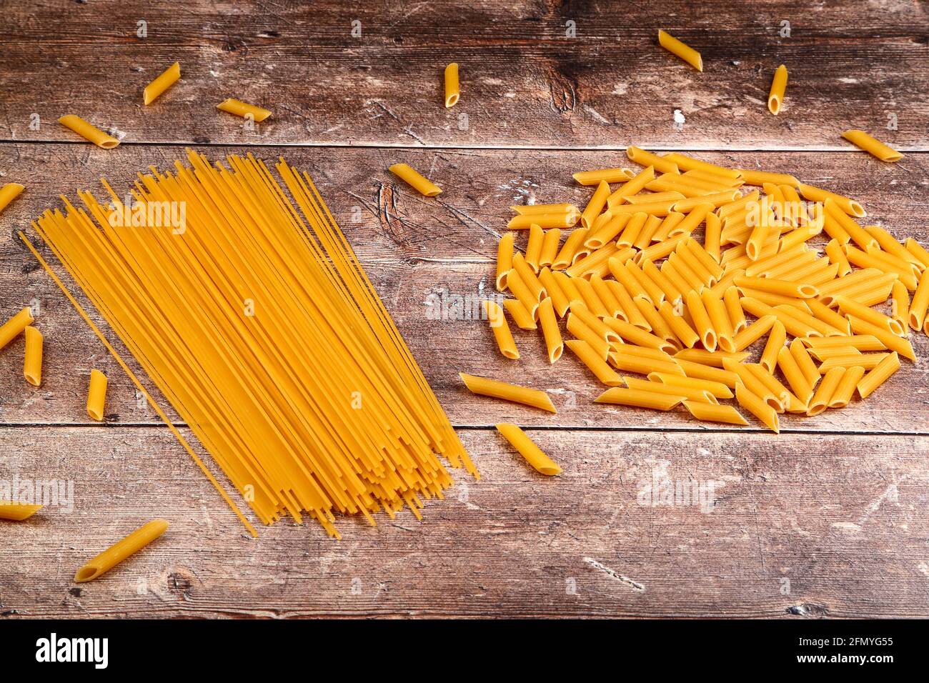 Nudelformen und Spaghetti auf einer Holztischplatte Stockfoto