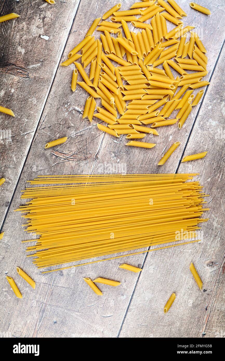 Nudelformen und Spaghetti auf einer Holztischplatte Stockfoto