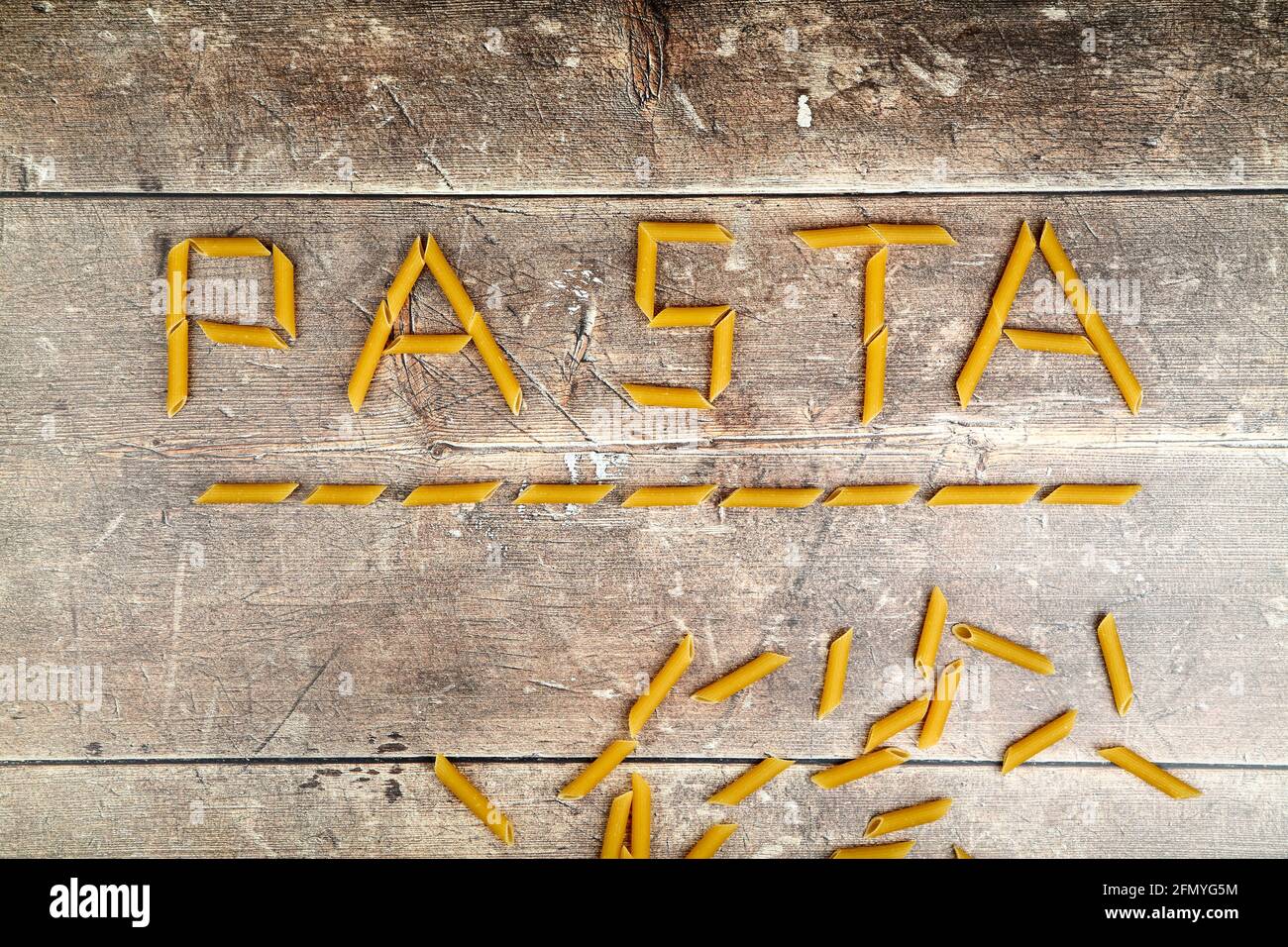 Pasta formt das Wort Pasta auf einem Holztisch Oben Stockfoto
