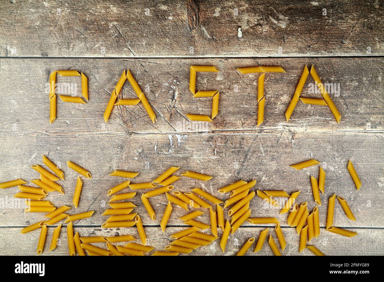 Pasta formt das Wort Pasta auf einem Holztisch Oben Stockfoto
