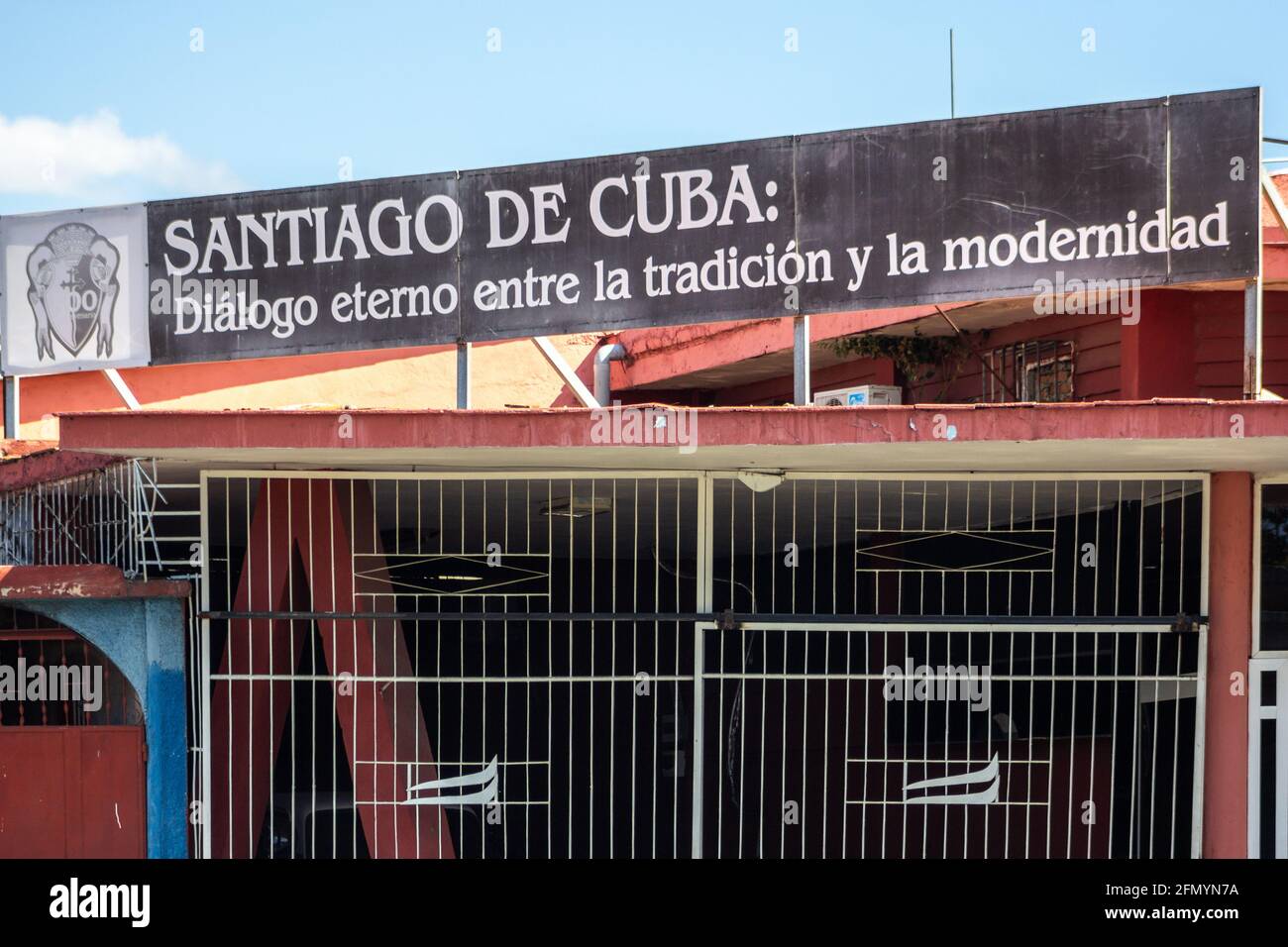 Anti-Diebstahl-Metallarbeiten in einem Gebäude. Oben steht ein Schild mit der Aufschrift "Santiago ein Dialog zwischen Tradition und Moderne, in Santiago de Cuba, Cub Stockfoto