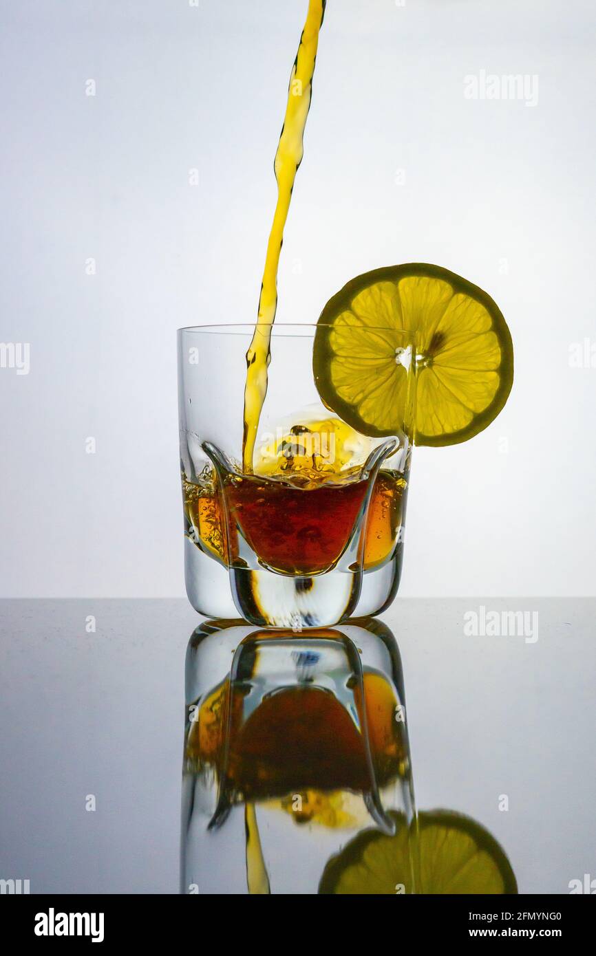 Gieße Tee in ein Glas mit Zitronen-Eistee Stockfoto