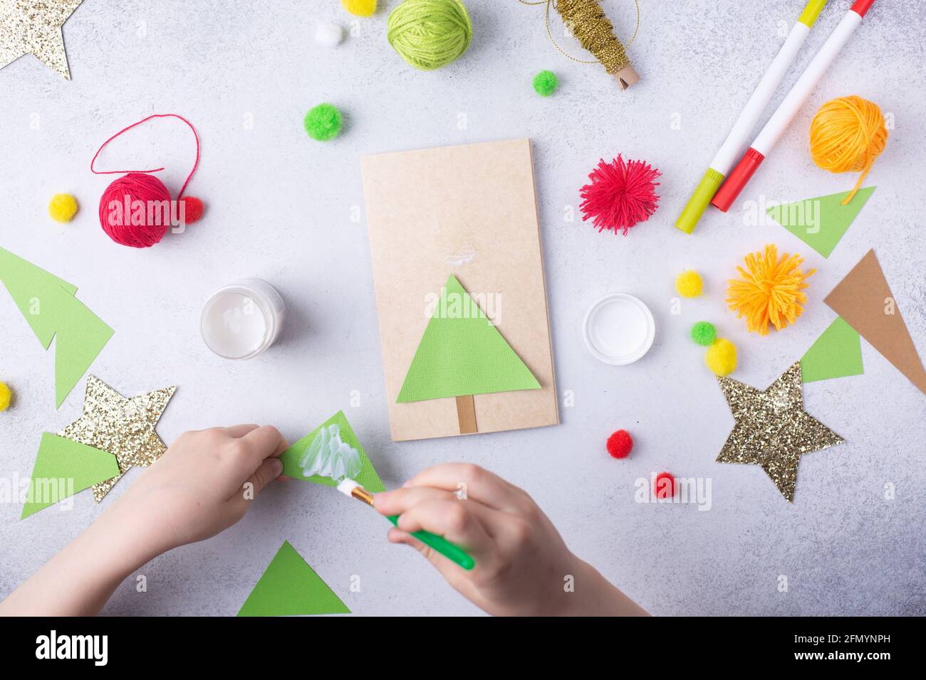 Das Kind macht eine Grußkarte Weihnachtspapier Collage. Kinder Kunst Projekt Handwerk für Kinder Stockfoto