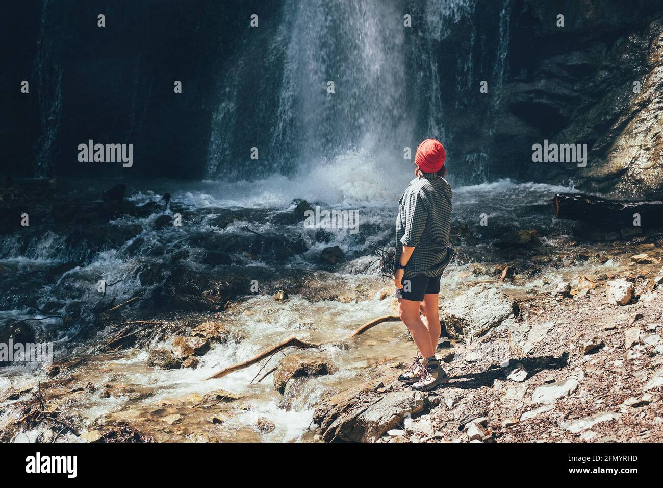 Frau gekleidet aktive Trekking-Kleidung in der Nähe des Gebirgswasserfalls und genießen Sie die spritzende Natur Kraft. Reisen, Trekking und Natu Stockfoto