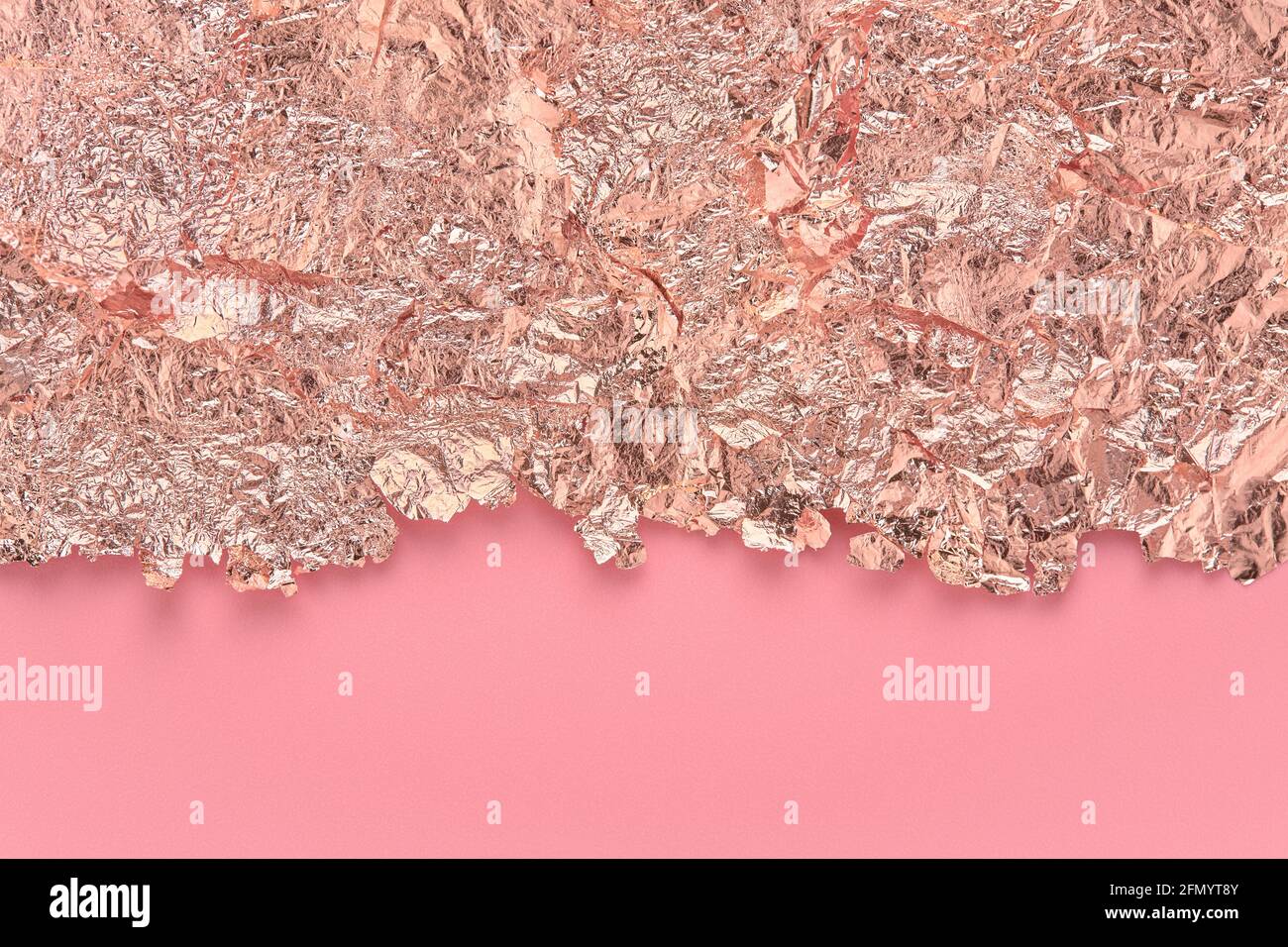 Blattgold-Bordüre, abgerissene Folienränder auf rosa, abstraktem Hintergrund. Stockfoto
