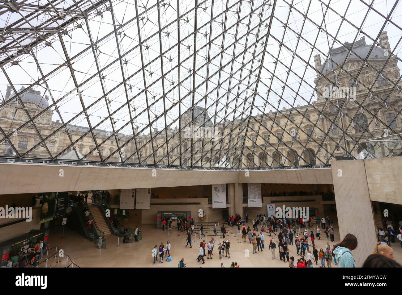 PARIS - Interier des Louvre Museums. Menschen, die auf Treppen unterhalb der Luvre-Pyramide laufen. Stockfoto