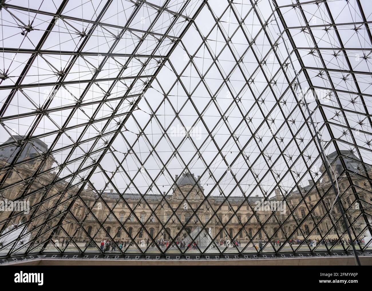 PARIS - Interier des Louvre Museums. Menschen, die auf Treppen unterhalb der Luvre-Pyramide laufen. Stockfoto