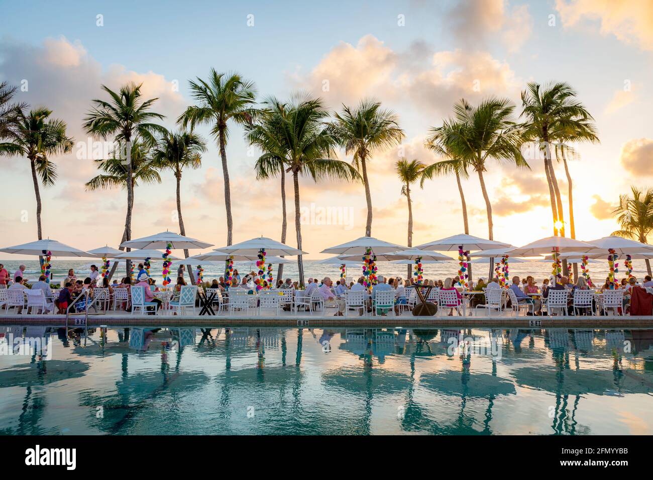 Am Strand stehen Sitzgelegenheiten und Sonnenschirme für eine Abendparty, Naples, Florida, USA, zur Verfügung Stockfoto