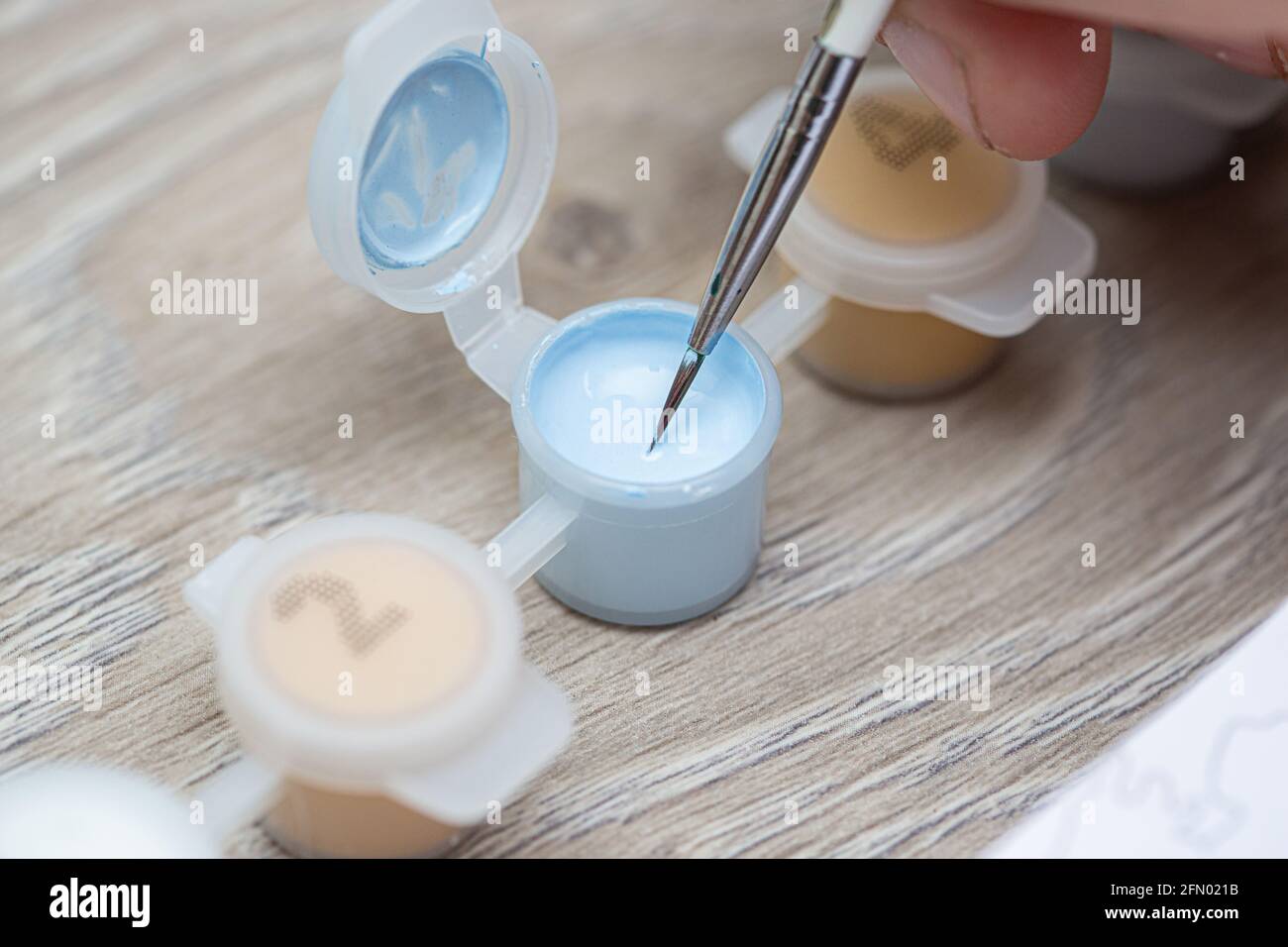 Eine mans Hand mit einem Pinsel zum Zeichnen von Nahaufnahme. Malen für Anfänger.Nahaufnahme, selektiver Fokus. Stockfoto