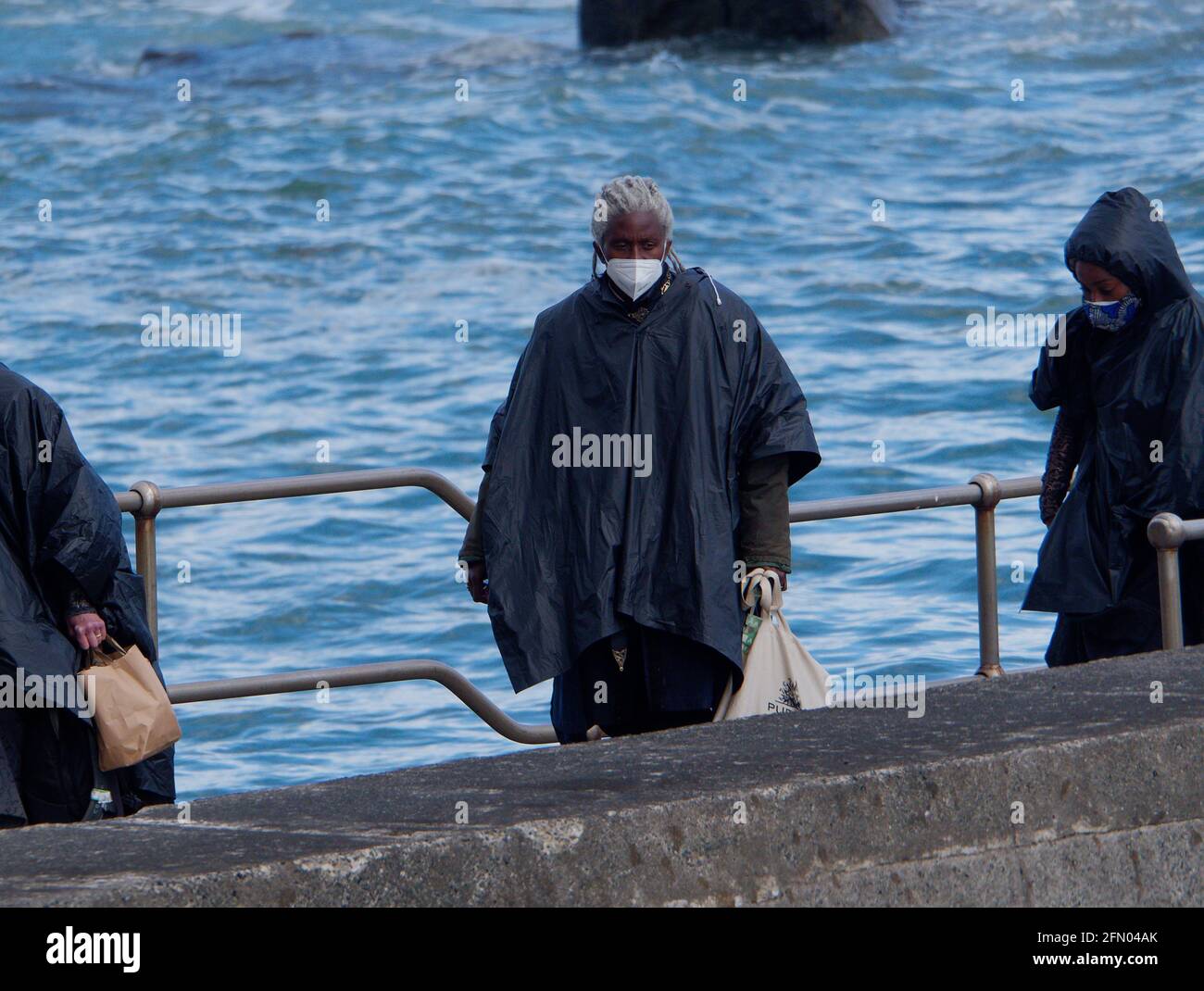 Penzance, Großbritannien. Mai 2021. Cornwall UK, St. Michaels Mount, House of Dragon. Viele der Darsteller ohne Gesichtsmasken. Die Schauspieler kehren von der Insel über eine halbe Meile offenes Meer zurück, eingewickelt in wasserfeste Umhänge, um die teuren Kostüme zu schützen. Eine raue Bootsfahrt von den Dreharbeiten auf der Insel St. Michaels Mount bis zur Hafenmauer von Marazion. April 2021. Kredit: Robert Taylor/Alamy Live Nachrichten Stockfoto