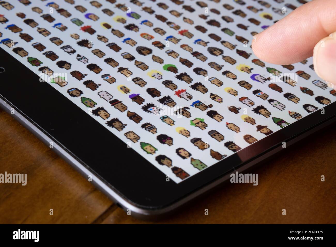CryptoPunks NFT-Zeichen, die auf dem Bildschirm des Tablets angezeigt werden. Eines der ersten nicht fungiblen Token, die von Larva Labs erstellt wurden. Selektiver Fokus. Stafford, United Stockfoto