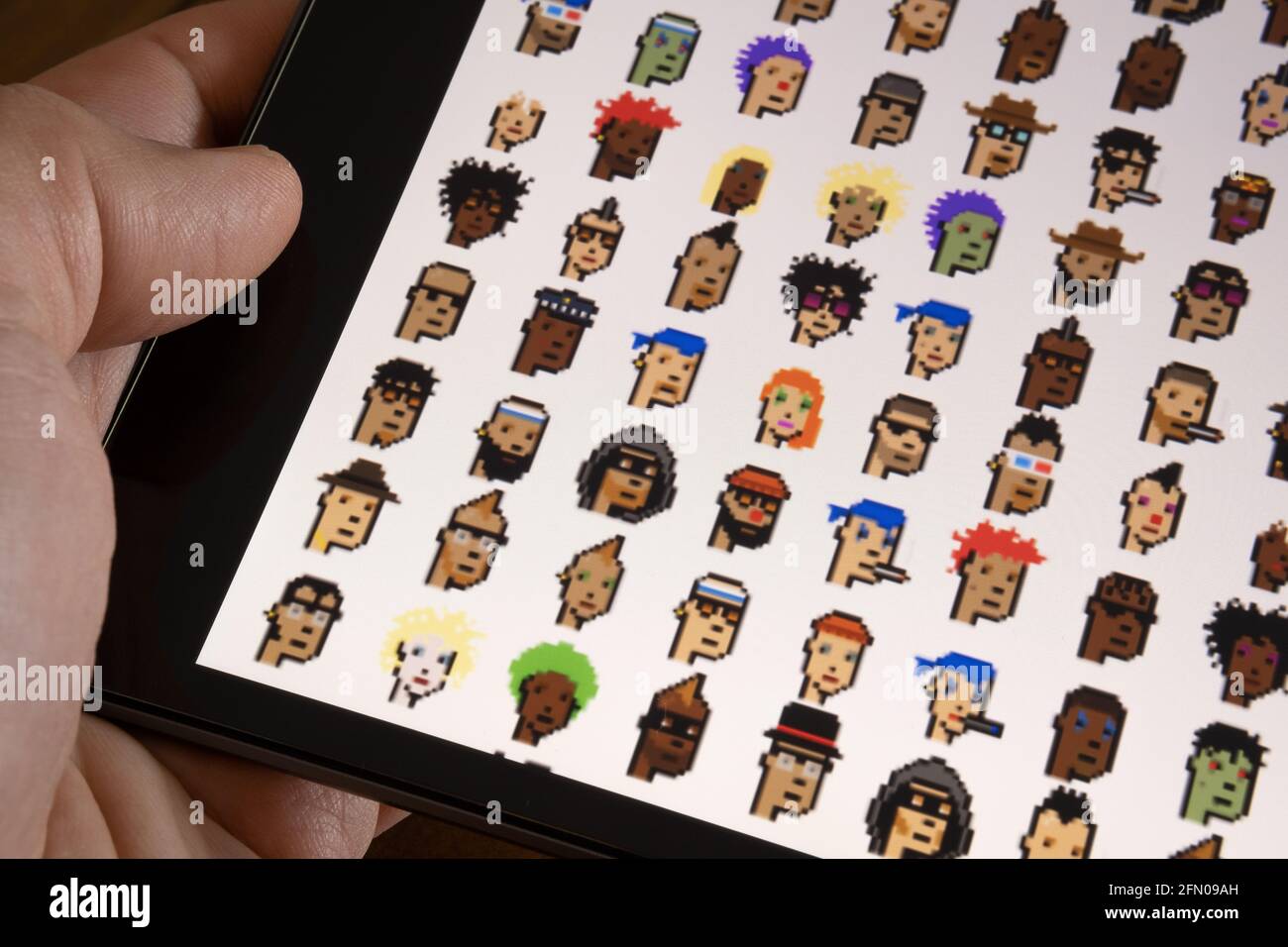 CryptoPunks NFT-Zeichen, die auf dem Bildschirm des Tablets angezeigt werden. Eines der ersten nicht fungiblen Token, die von Larva Labs erstellt wurden. Selektiver Fokus. Stafford, United Stockfoto